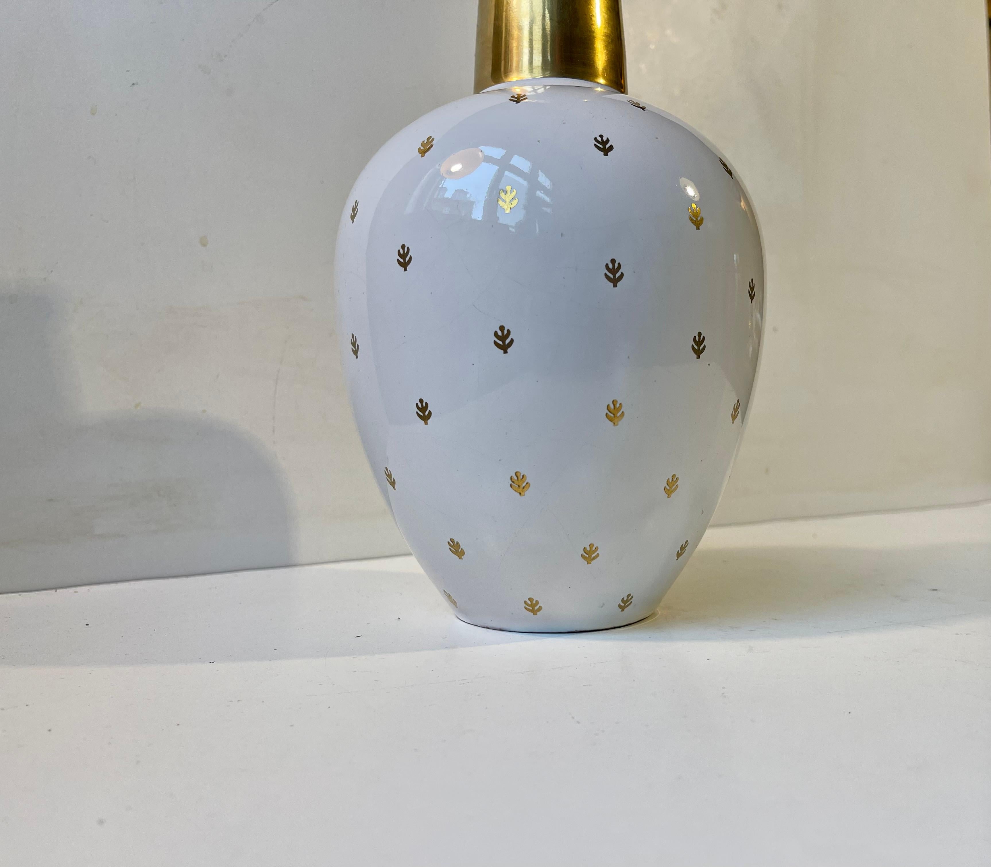 A stylish ovoid ceramic vase decorated with gold foliage on a white glazed main body. Un-identified Scandinavian/German design/maker in the style of Wilhelm Kåge, Rosenthal and Arthur Percy. Suitable for modern, midcentury or Hollywood Regency