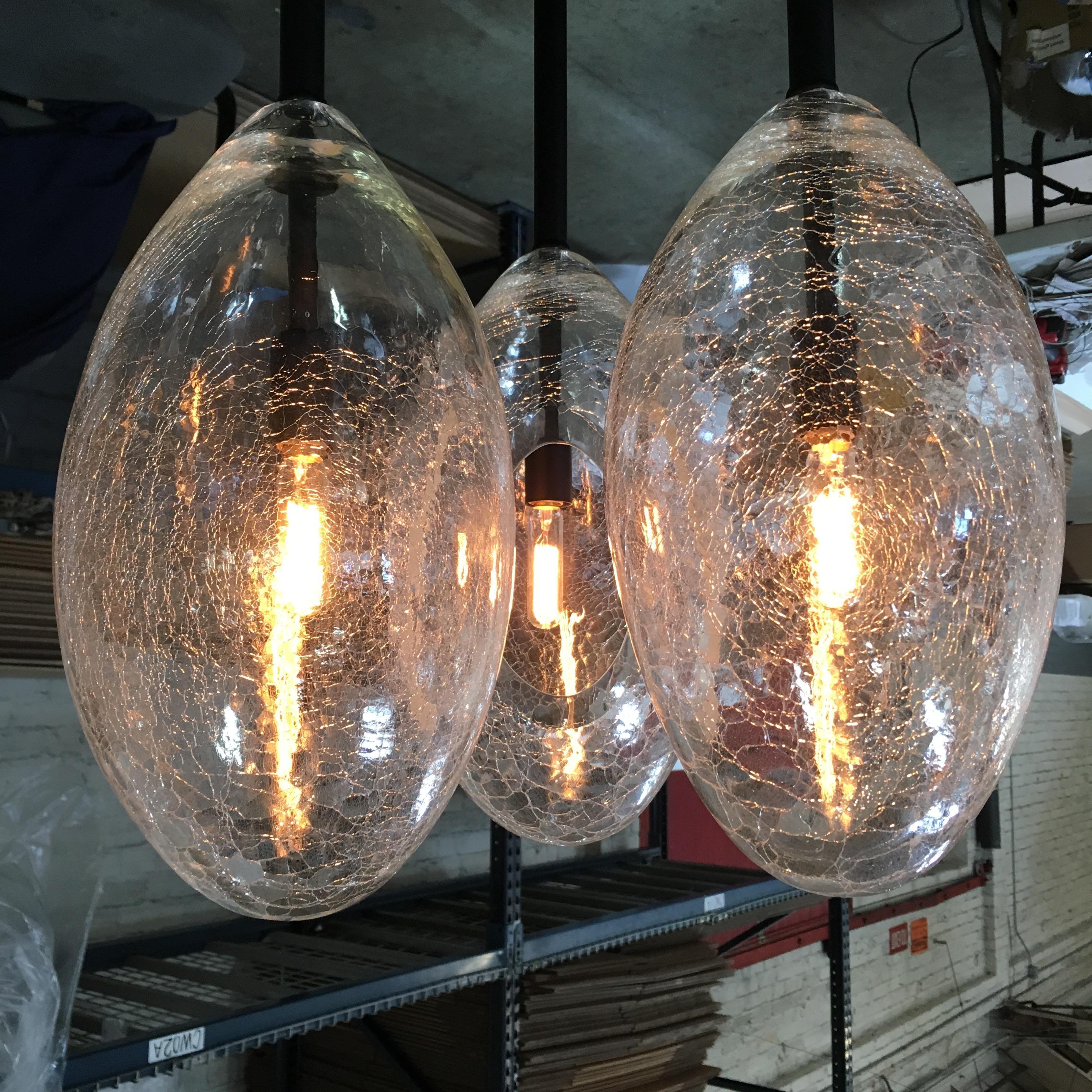 Overscale hand-blown crackle glass 'eggs' sparkle and refract light. A striking solo note or a cascade of shape and light, Ovovo is sensuous with a touch of 60's whimsy.

Flash-cracked and fire-blown glass with polished brass or nickel.

Models in