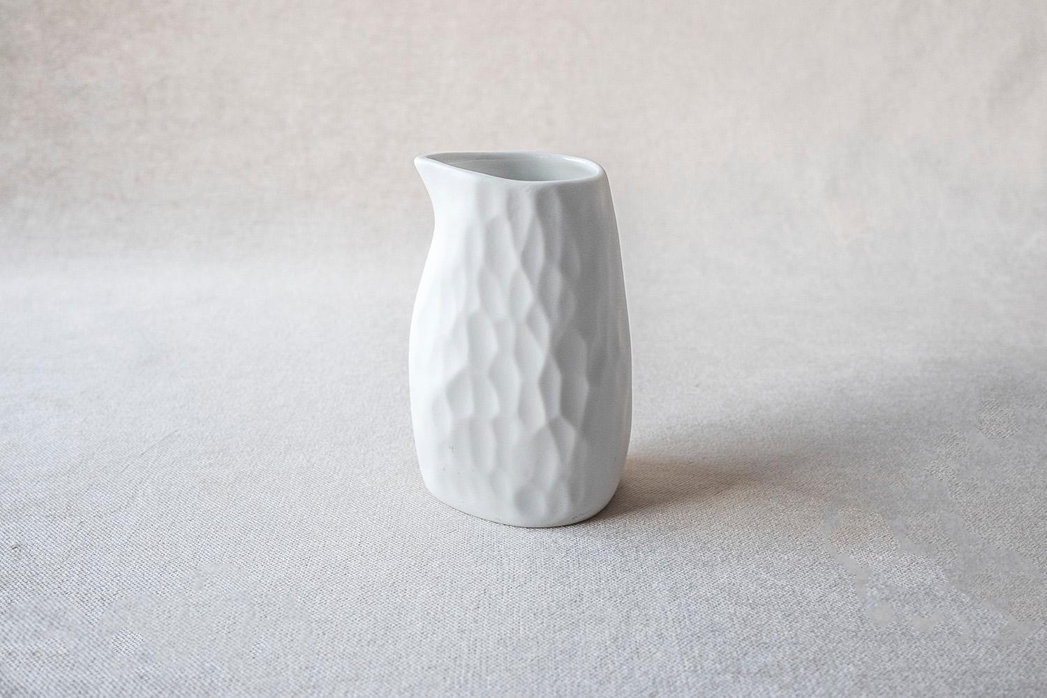 • Beautiful creamer 
• Measures: 10 cm high x 5 cm diameter
• Perfect to hold and pour olive oil, sauces and creams
• Unglazed outside with an organically carved texture
• Glazed white on the inside
• Designed in Amsterdam / handmade in