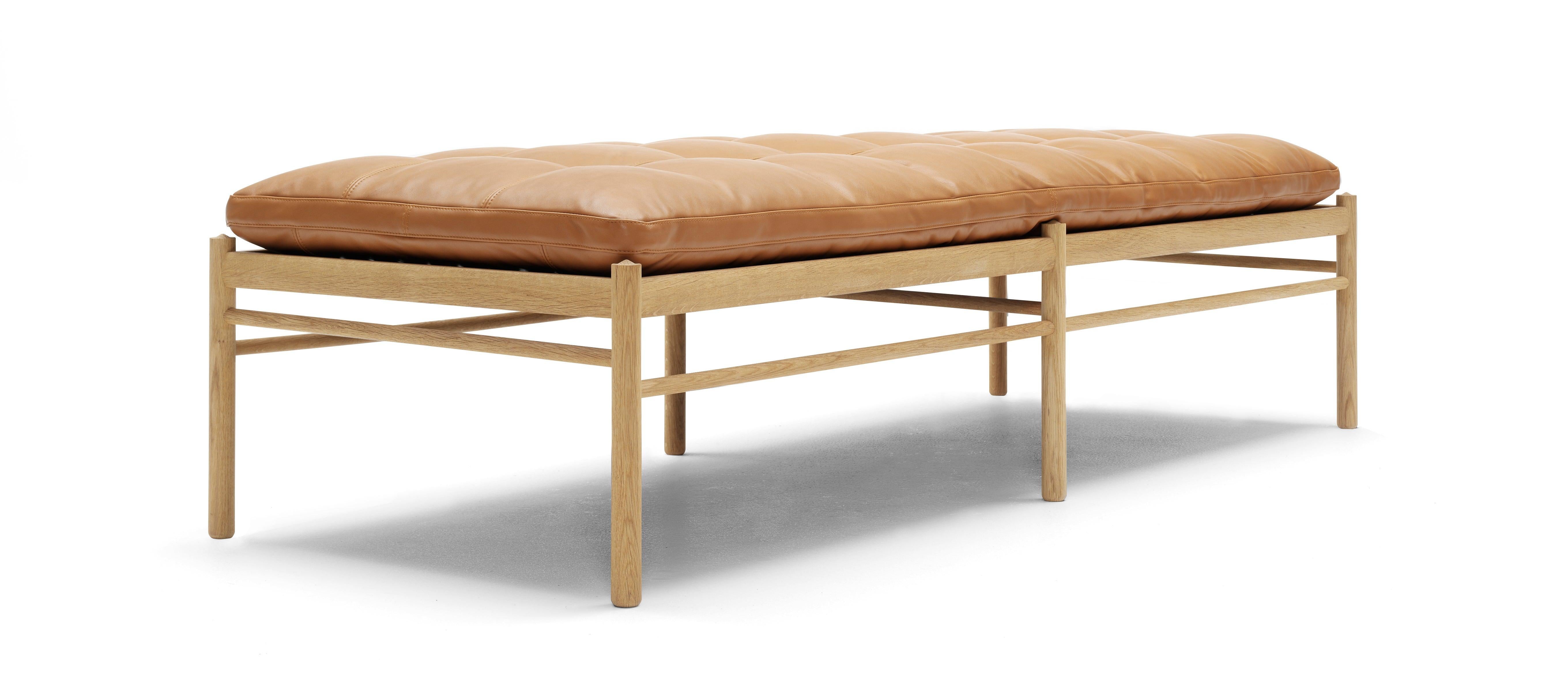 The clean, Classic OW150 daybed designed by Ole Wanscher in 1949 features a single long cushion that appears to float above an angular, solid oak frame. It is, however, supported by a delicate yet strong cotton webbing. Hand-sewn buttons create a