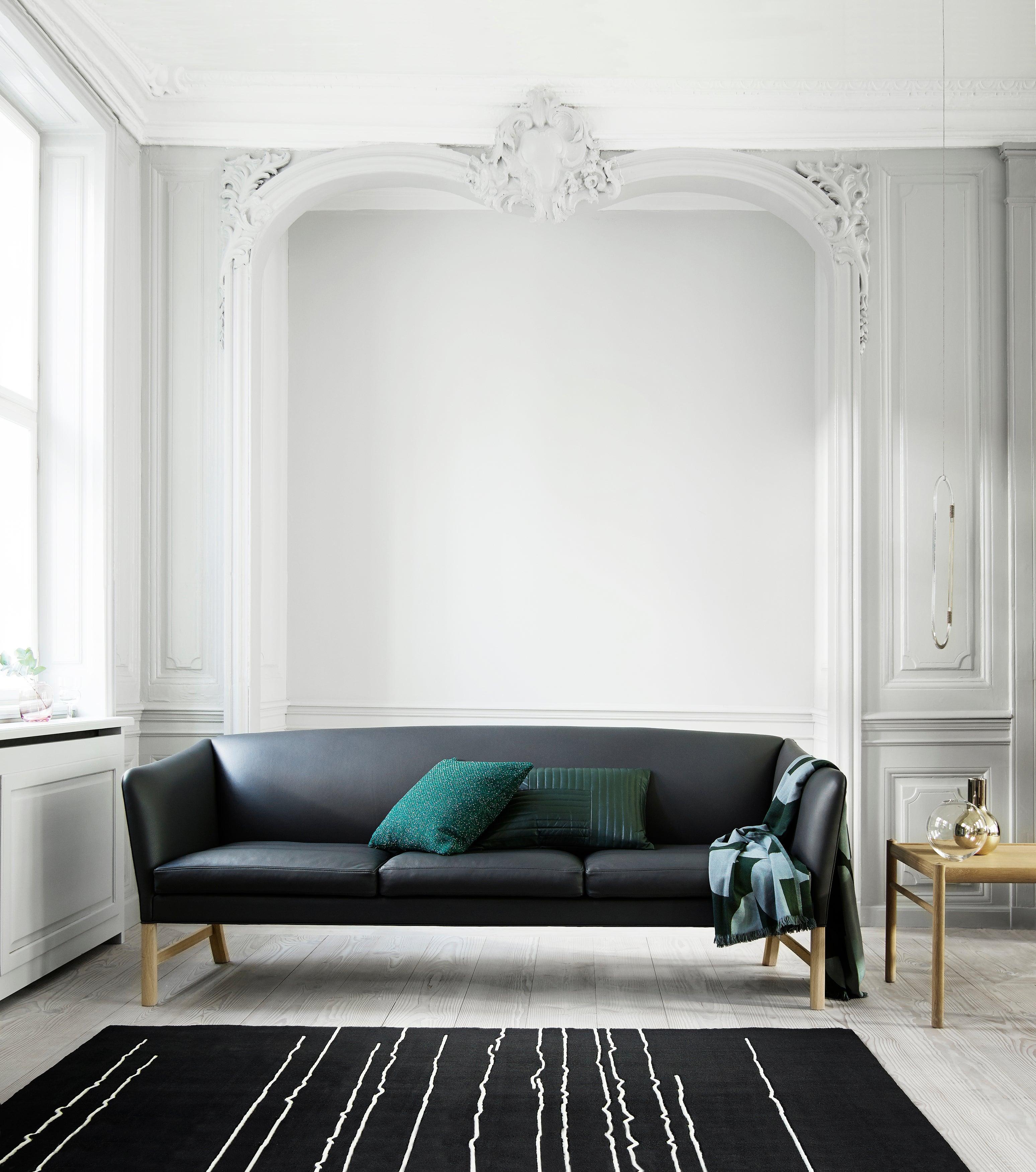 The OW603 sofa by Ole Wanscher is a classic and luxurious three-seat sofa ideal for larger modern interiors. This masterpiece from 1960 was inspired by classic English and Oriental furniture and forms part of a complete living room set designed by