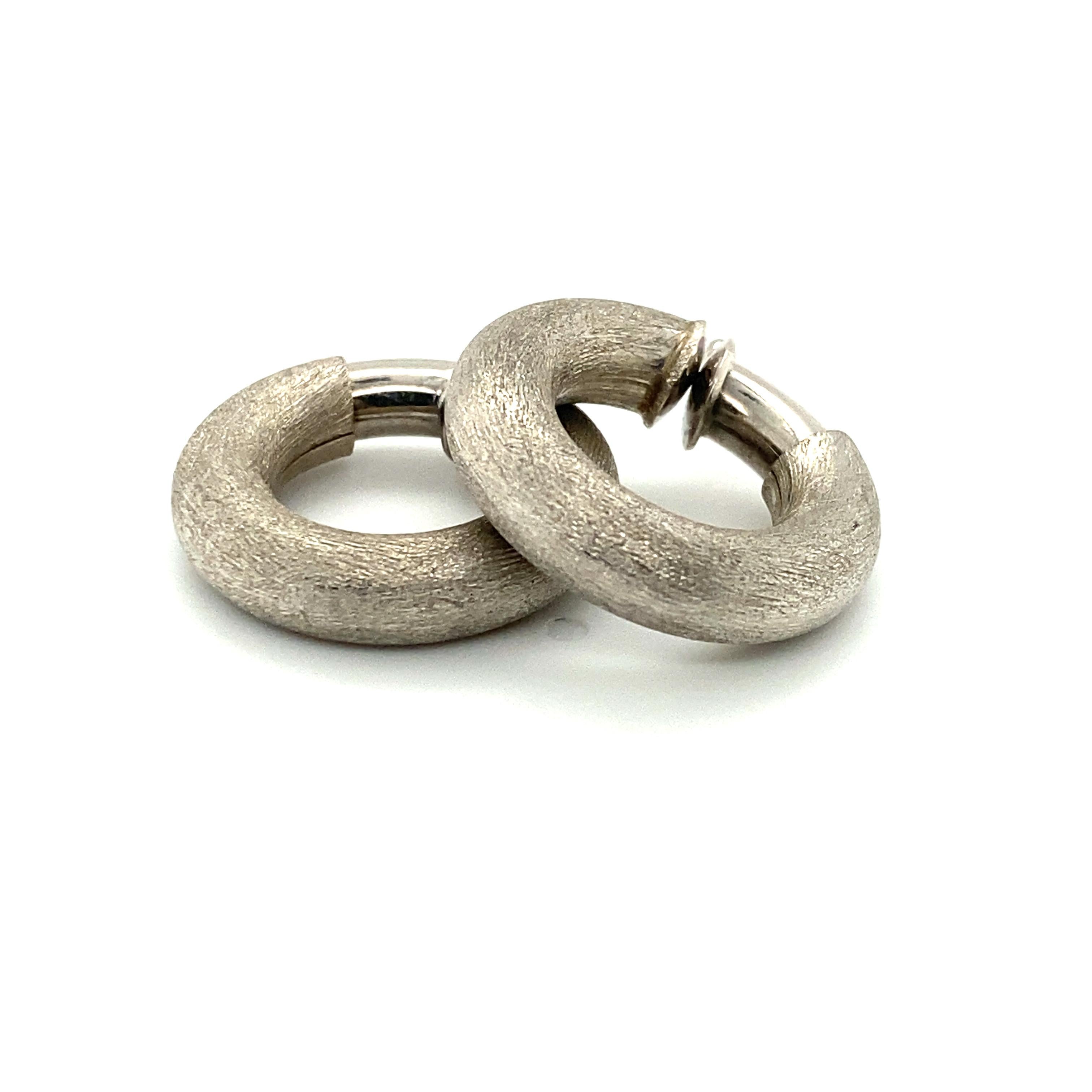 A pair of textured Italian 18k white gold hoop earrings from OWC.  This pair would have been individually textured using a hand tool in a labor-intensive process, and the resulting texture scatters light in such a way that parts of the surface