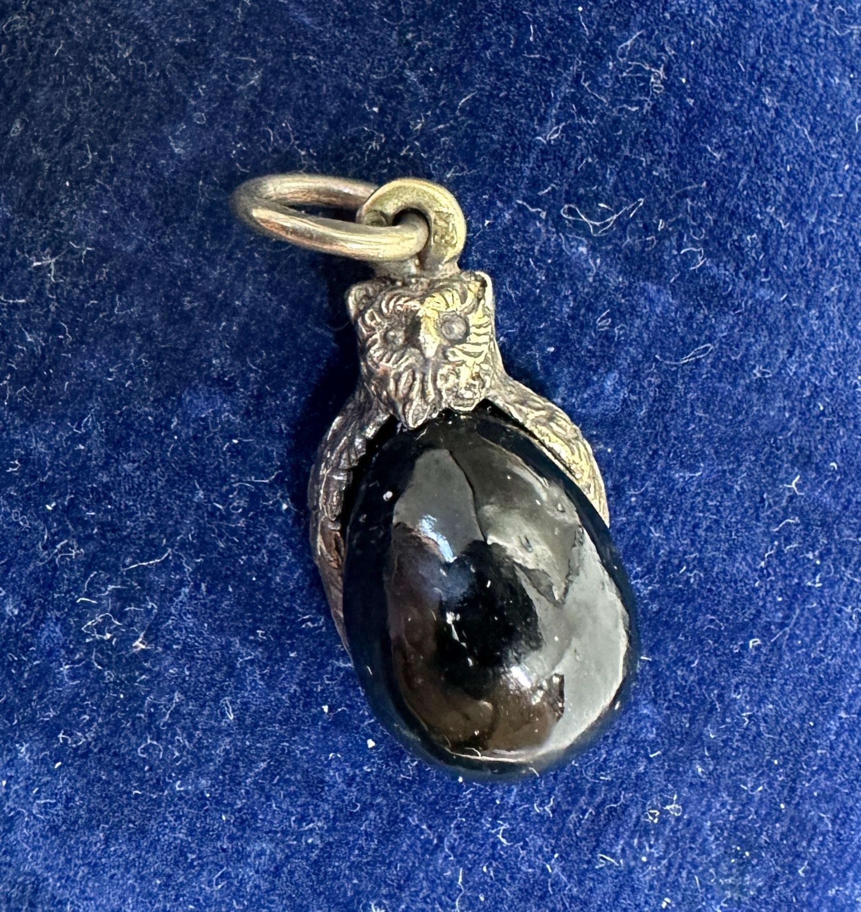 This is a Russian hand carved Black Jade Owl Easter Egg Pendant or Charm in 84 Silver. The pendant is adorned with a Silver mount on top modeled as an owl with wings, engraved with detailed patterns over a Black Jade egg. The Owl pendant is