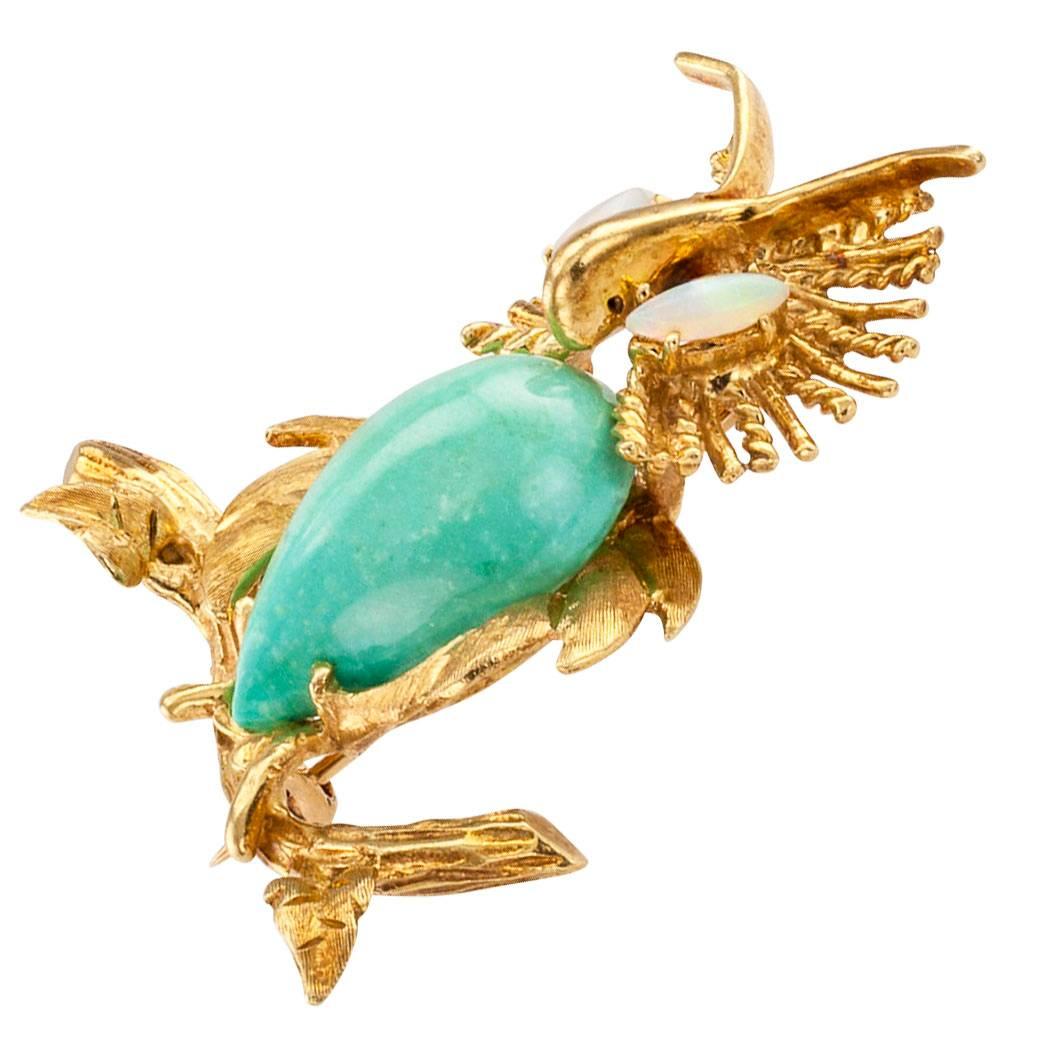 Owl gold brooch 1960s with opal eyes and turquoise body. The whimsical design features an owl perched on a branch and looking right at you with its opal eyes, its body formed by a cabochon, teardrop-shaped, green turquoise, framed by fluffy looking