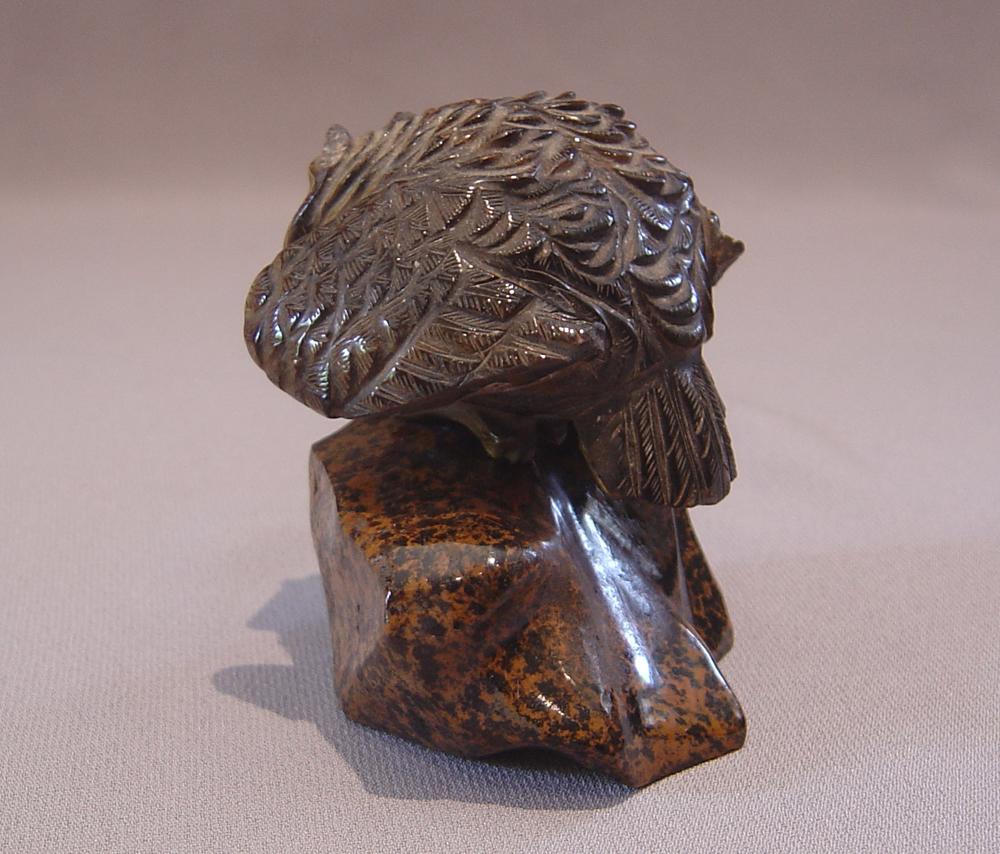A beautifully carved model of an owl entirely carved from the solid in Tigers Eye (which is a chatoyant gemstone that is usually yellow- to red-brown, with a silky luster, a member of the quartz group). The owl which has glass eyes is set upon a