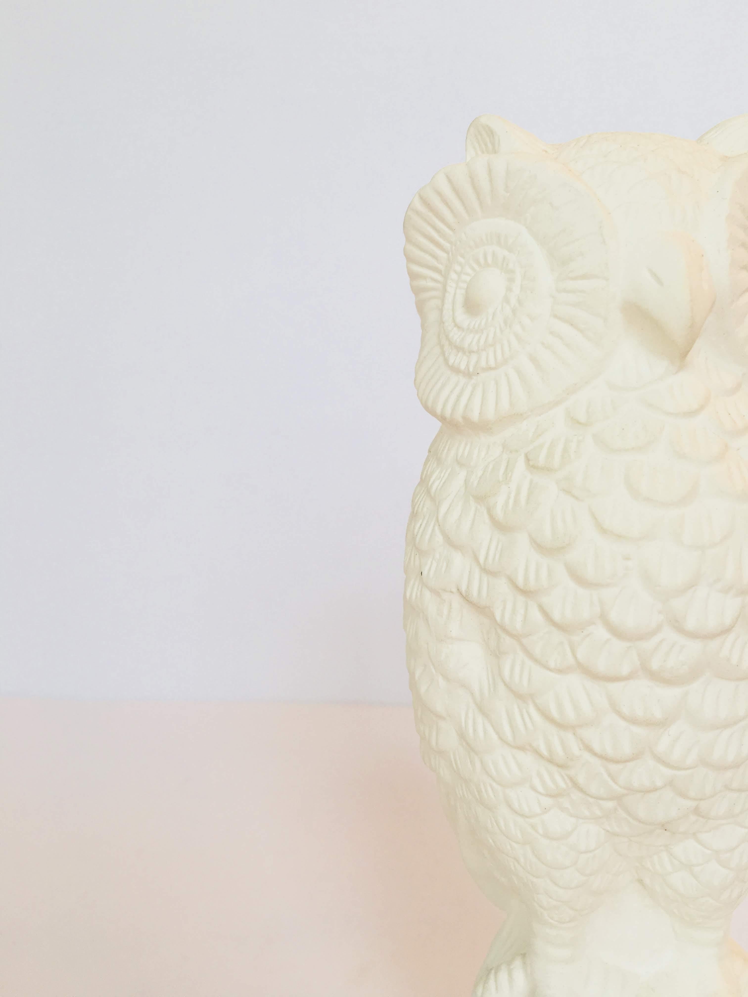 Owl sculpture- all white, sitting on branches.