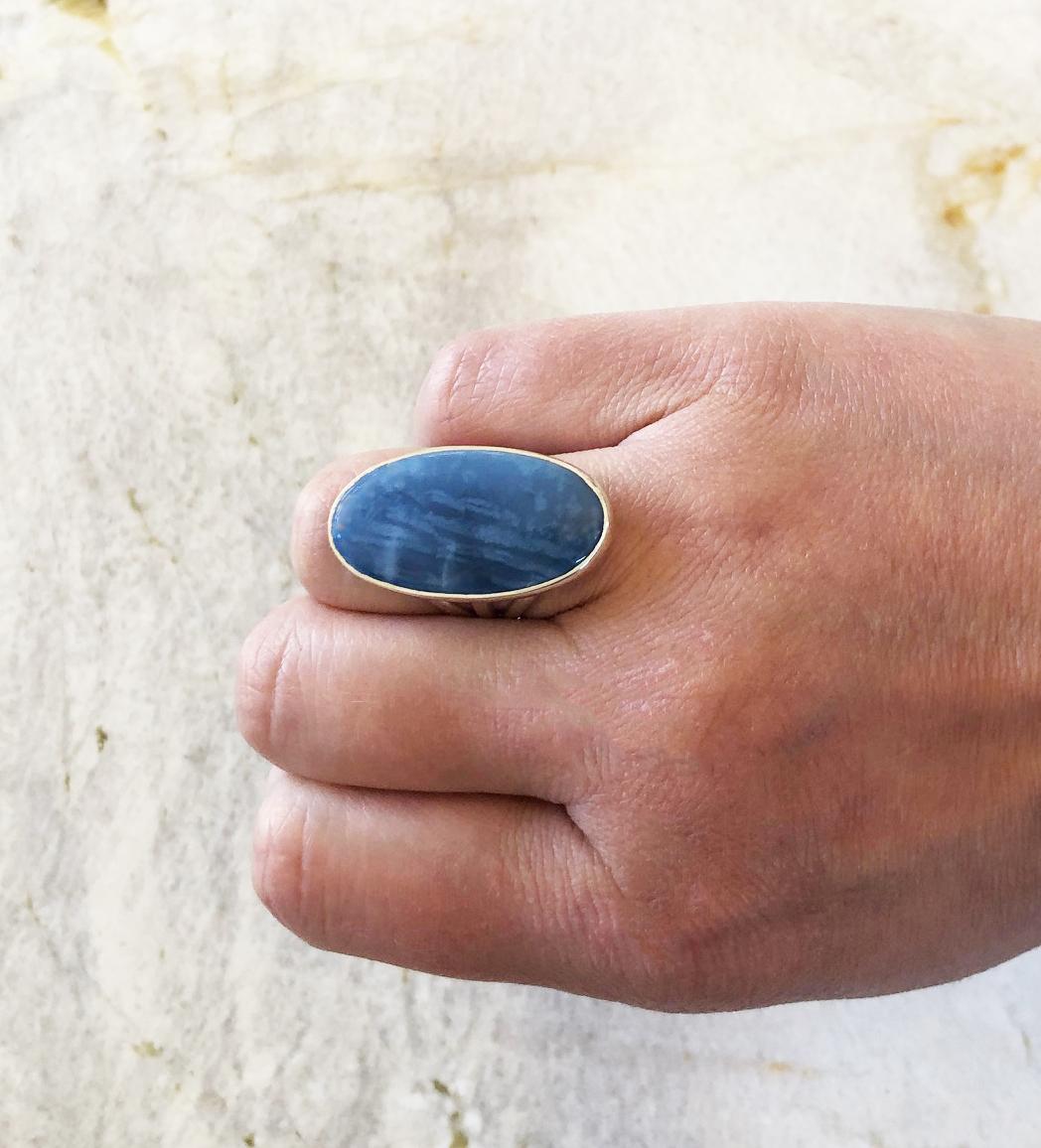 A stunning Owyhee blue opal cabochon was bezel set in sterling silver to make this one of a kind ring. The shank of the band is a simple and elegant split style and the bezel setting is very secure. The Owyhee blue opal stone is approximately 33mm