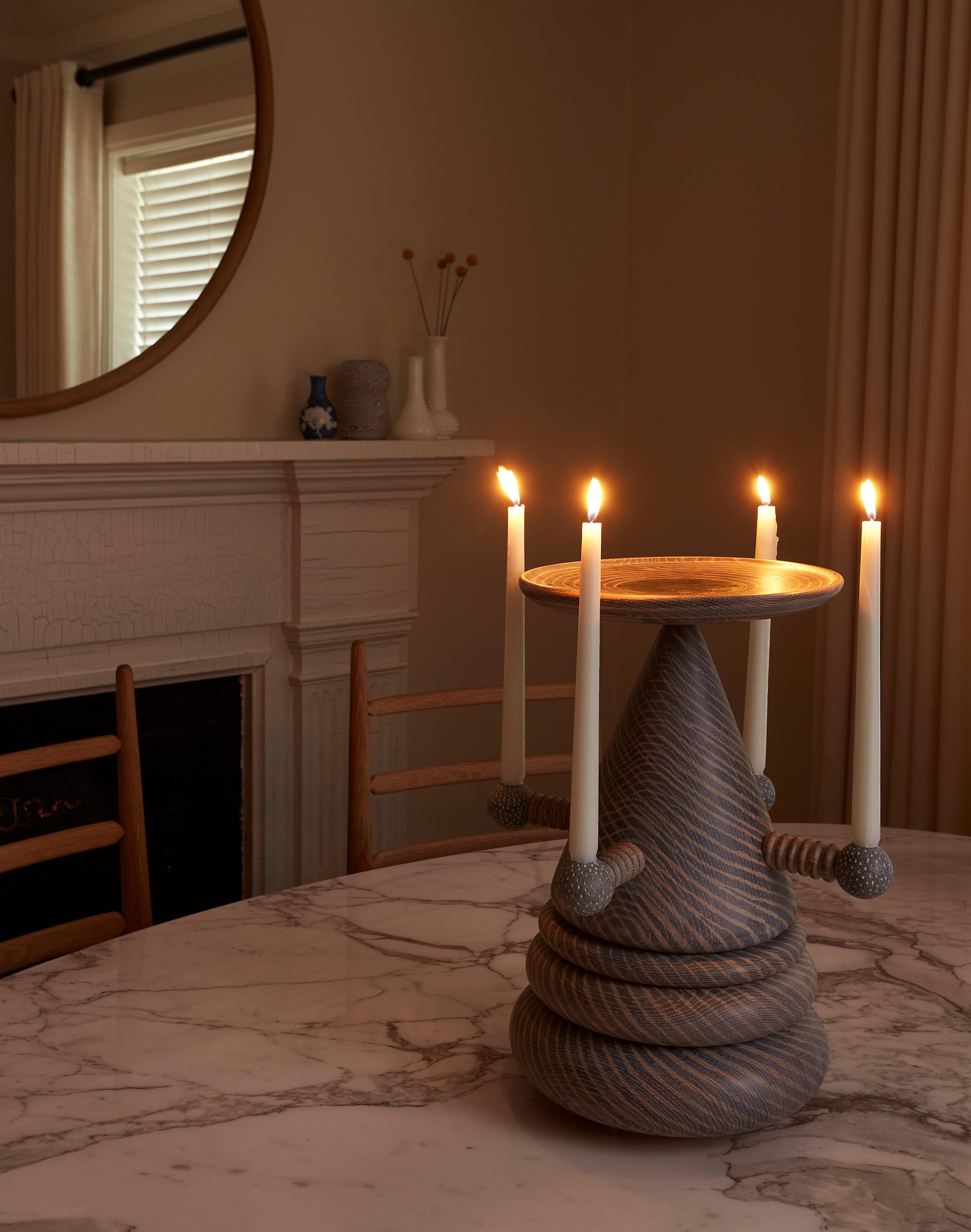 Esta pieza única y esotérica está diseñada para acoger ofrendas materiales y acciones de gracias, sirviendo como objeto decorativo panreligioso funcional y estéticamente agradable.

Nicholas Hamilton Holmes es un escultor y fabricante de muebles que