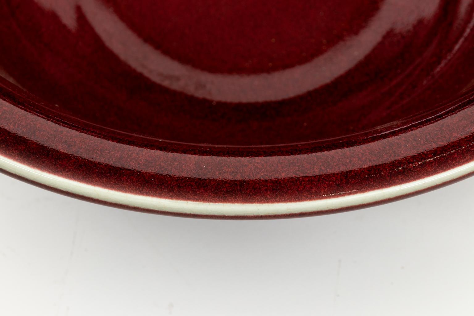 Ceramic Oxblood bowl in a glazed finish. Please note of wear consistent with age including minor finish loss.