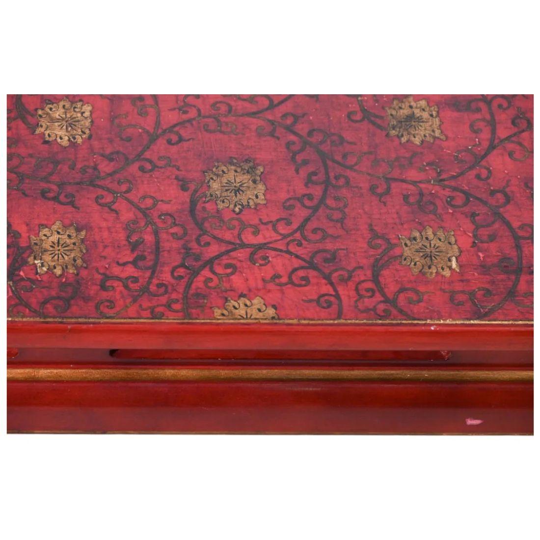 This Asian coffee table features a striking dark red lacquer finish with elegant Ming-style legs.  The table’s top is a captivating fusion of artistry, showcasing a glossy lacquered surface adorned with intricate black scrollwork and gold round