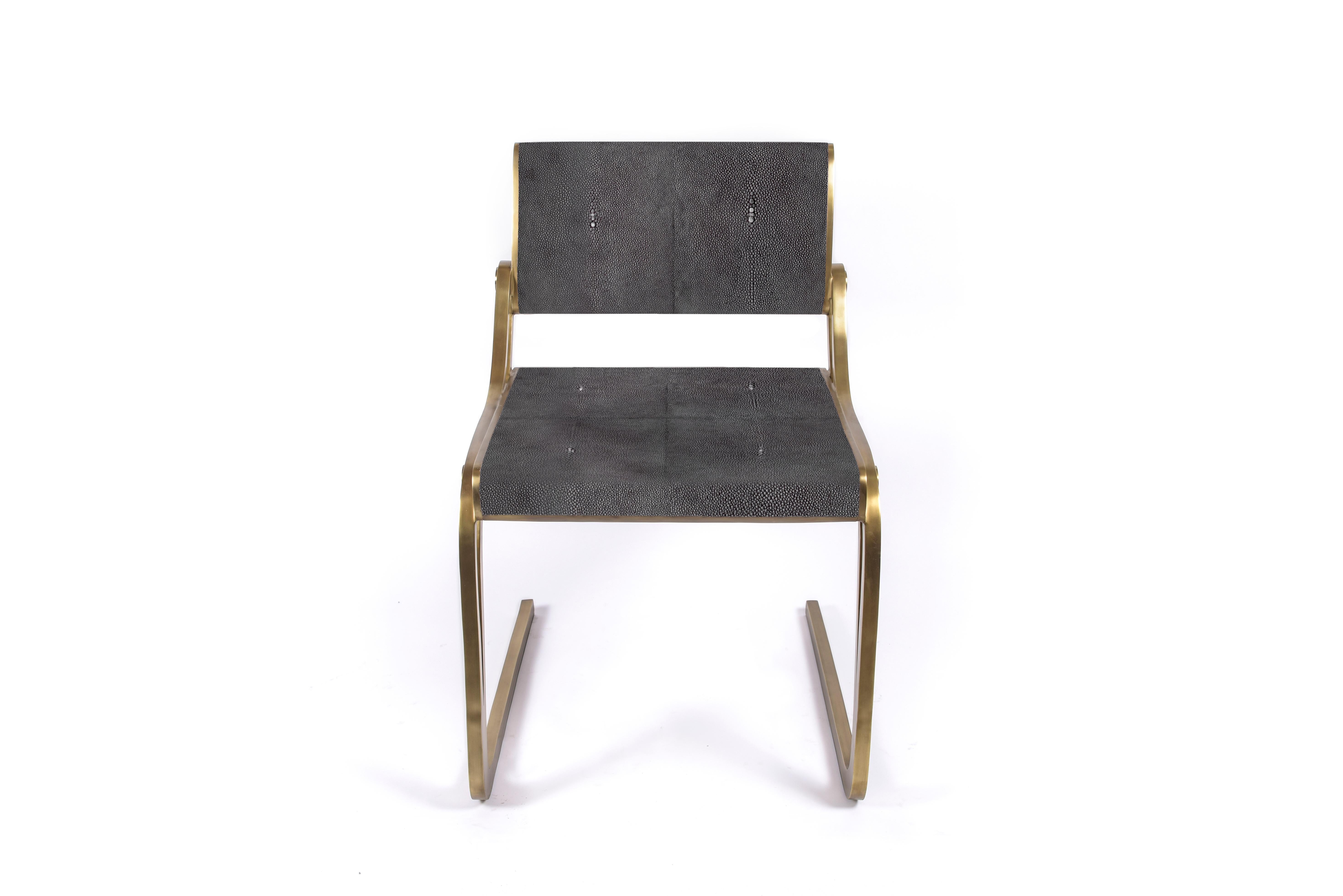 The Oxford chair by R&Y Augousti is a sophisticated piece that provides comfort, whilst retaining its elegant and luxurious aesthetic. This piece is inlaid in coal black shagreen, with a bronze-patina brass frame. Available in cream shagreen and
