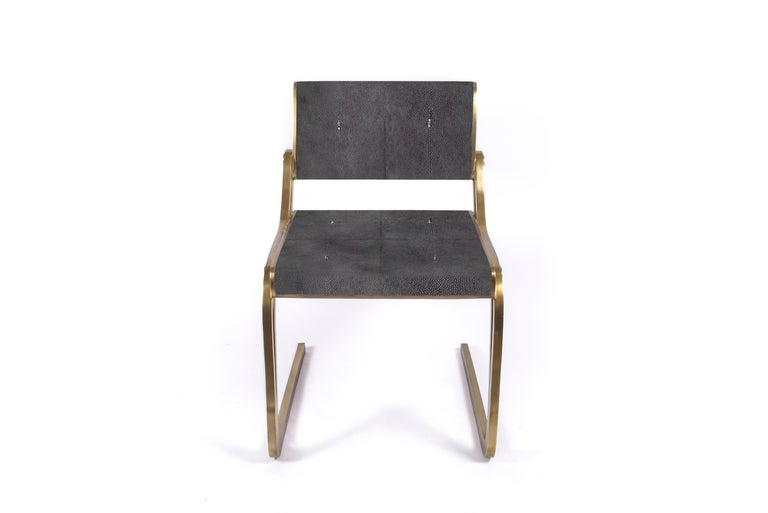 The Oxford chair by R&Y Augousti is a sophisticated piece that provides comfort, whilst retaining its elegant and luxurious aesthetic. This piece is inlaid in coal black shagreen, with a bronze-patina brass frame. Available in cream shagreen and