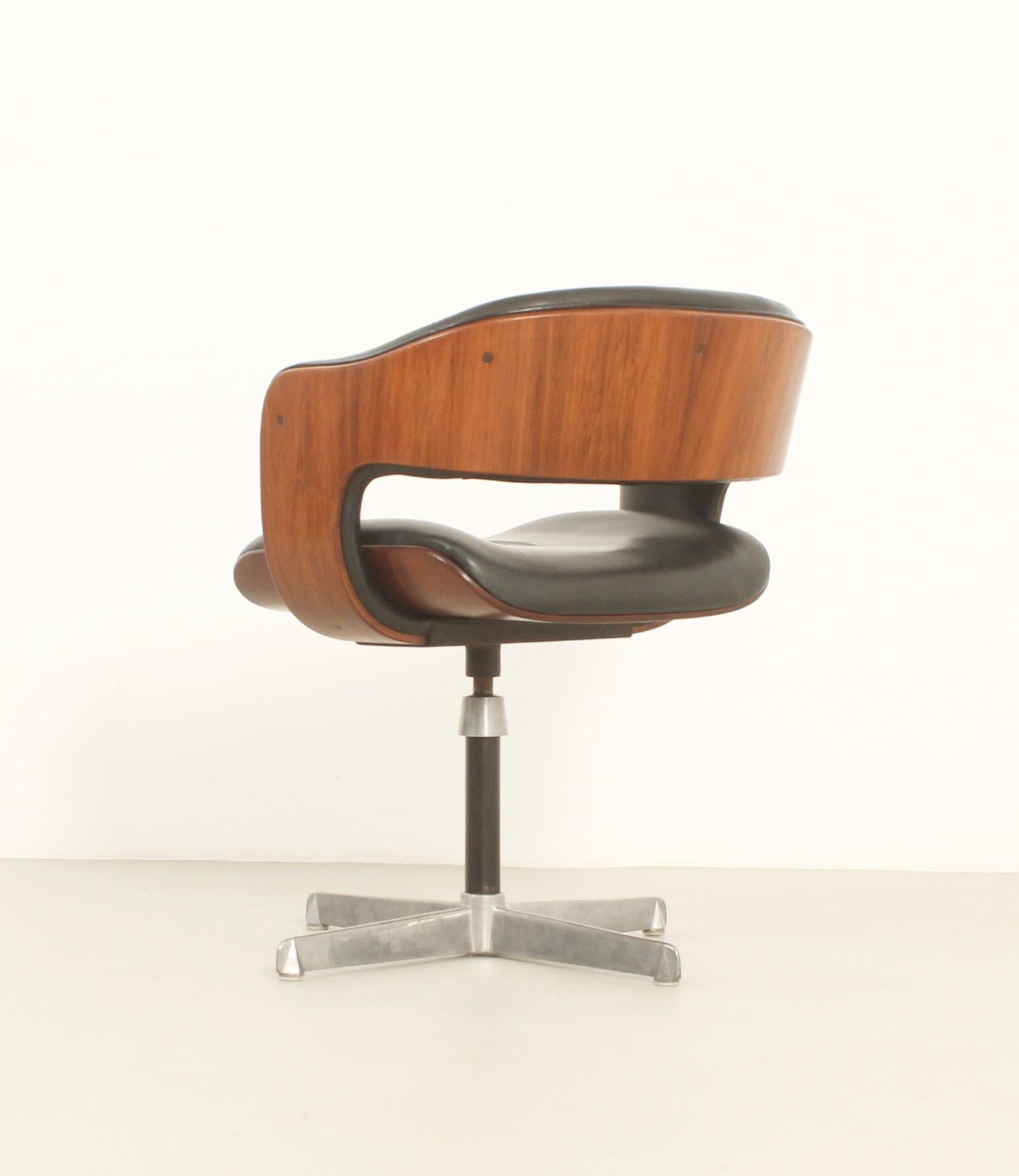 Oxford chair designed in 1963 by British designer Martin Grierson for Arflex, Italy. Hardwood molded shell upholstered in black leather. Swivel base in metal and polished steel adjustable in height. 