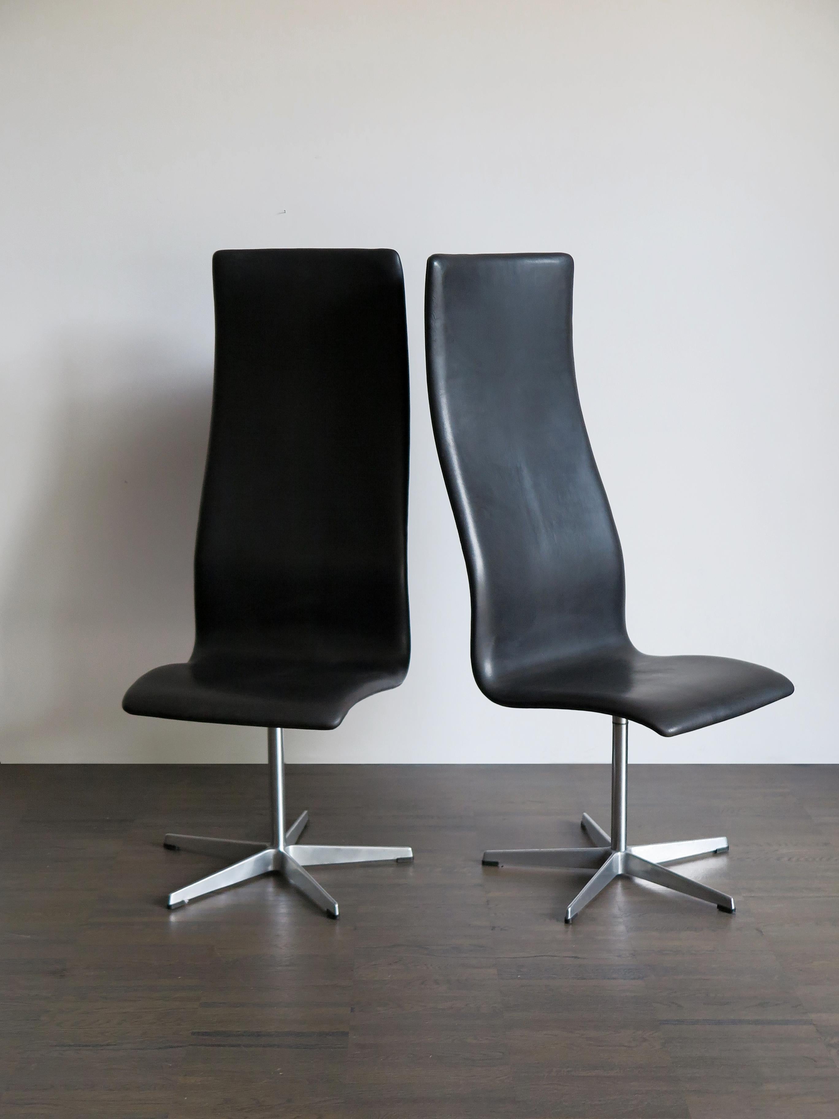 Set of two scandinavian midcentury modern design swivel “Oxford” office chairs designed by Arne Jacobsen and produced by Fritz Hansen with black leather upholstery and metal foot, manufacturer’s adhesive label, 1960s

Please note that the items