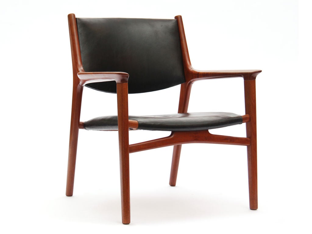 Ein sehr seltener Sessel aus Teakholz, der die originale Sitz- und Rückenpolsterung aus schwarzem Rindsleder beibehält. Entworfen von Hans J. Wegner und hergestellt von Johannes Hansen um 1950 in Dänemark.