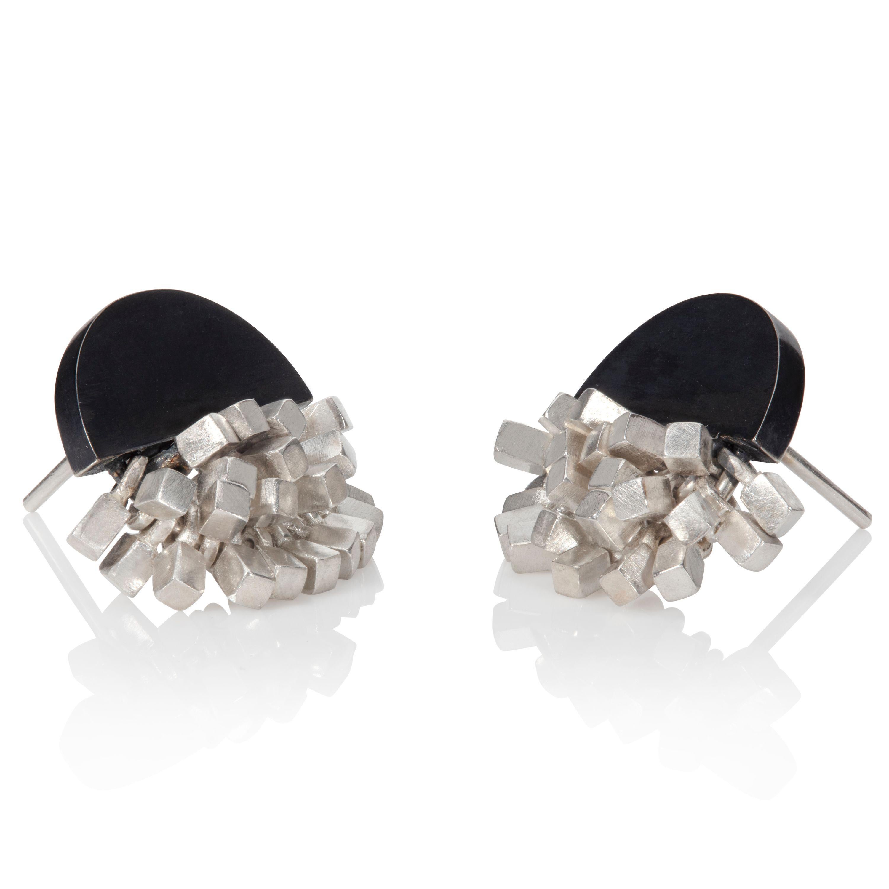 These earrings are designed and made by UK jeweler Sarah Pulvertaft. Adorning the bottom edge of the oxidised sterling silver half-circle are many individual mini cubes in a bright sterling silver. Moveable cubes, each capturing the reflection of