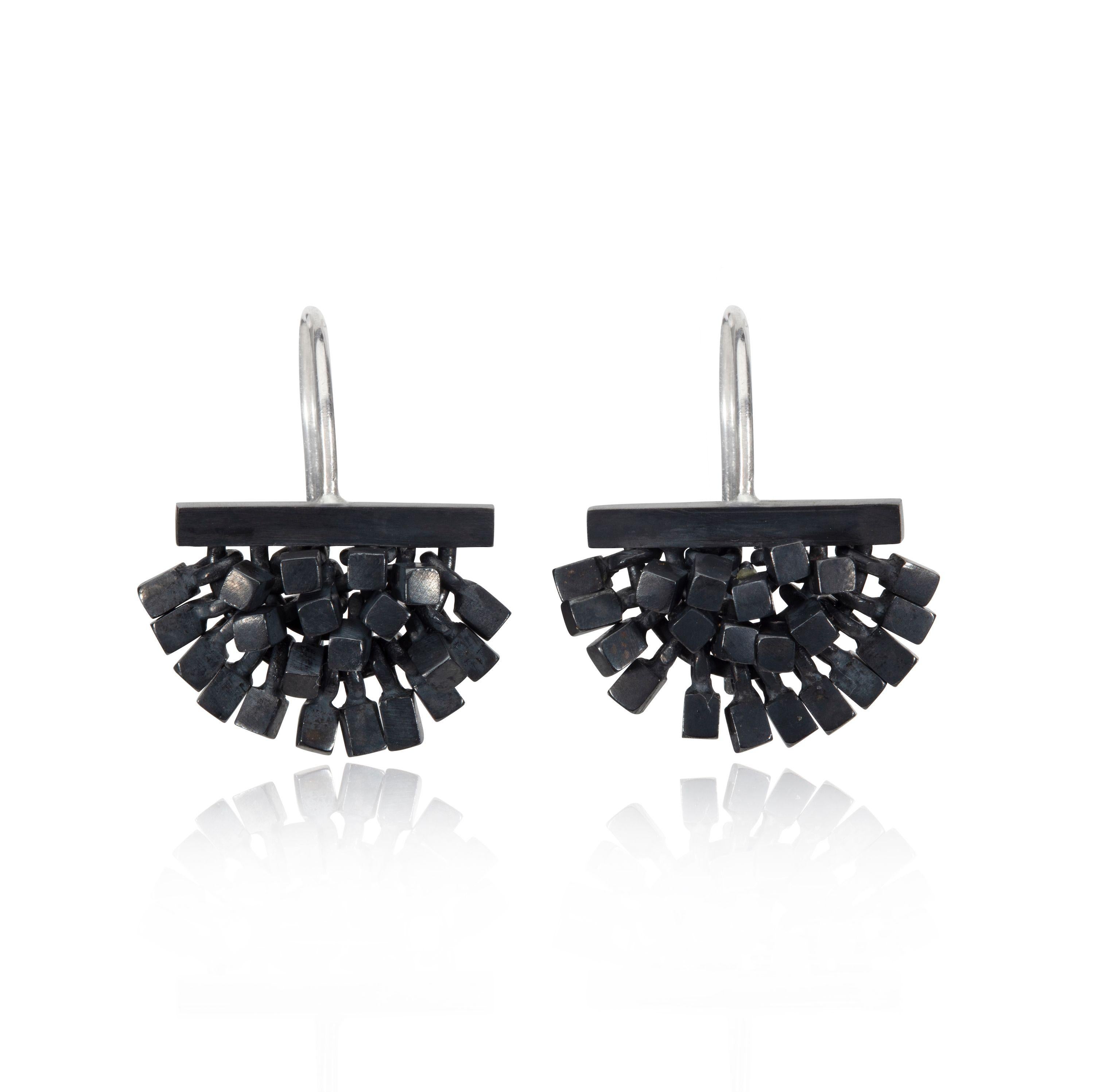 These earrings are designed and made by UK jeweler Sarah Pulvertaft. Done in a very contemporary oxidised sterling silver these earrings are comprised of individual mini cubes affixed to a horizontal bar. Moveable cubes, each capturing the