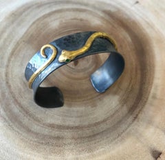 Manchette serpent en argent oxydé et or jaune 24K avec yeux en émeraude par Lika Behar