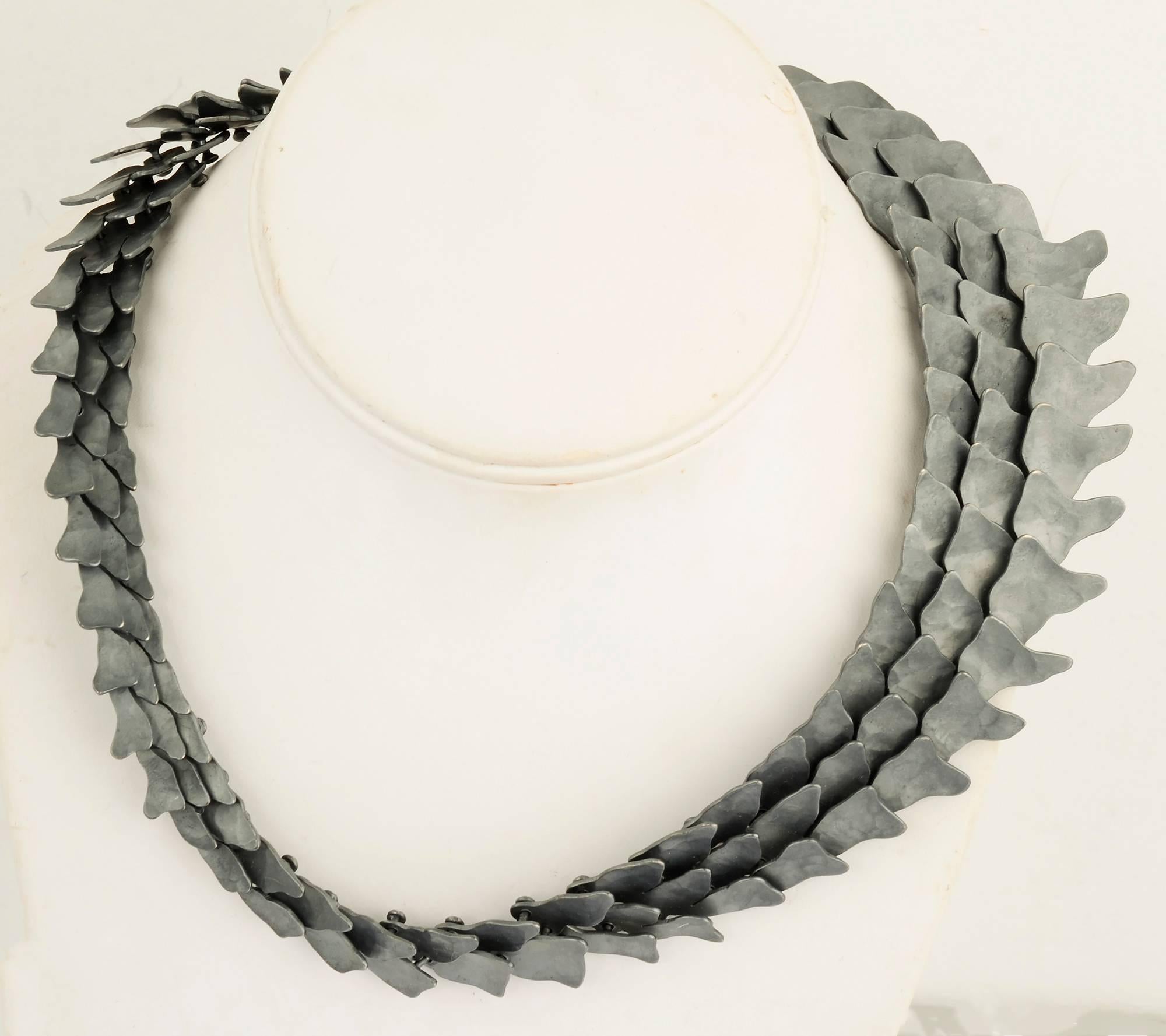 L'architecte Eduardo Herrera a mis ses compétences au service de la fabrication de bijoux. Ce collier remarquable est  fait  en argent 950, de meilleure qualité que le sterling. Le noir a été oxydé pour créer la finition sombre et mate.
Les maillons