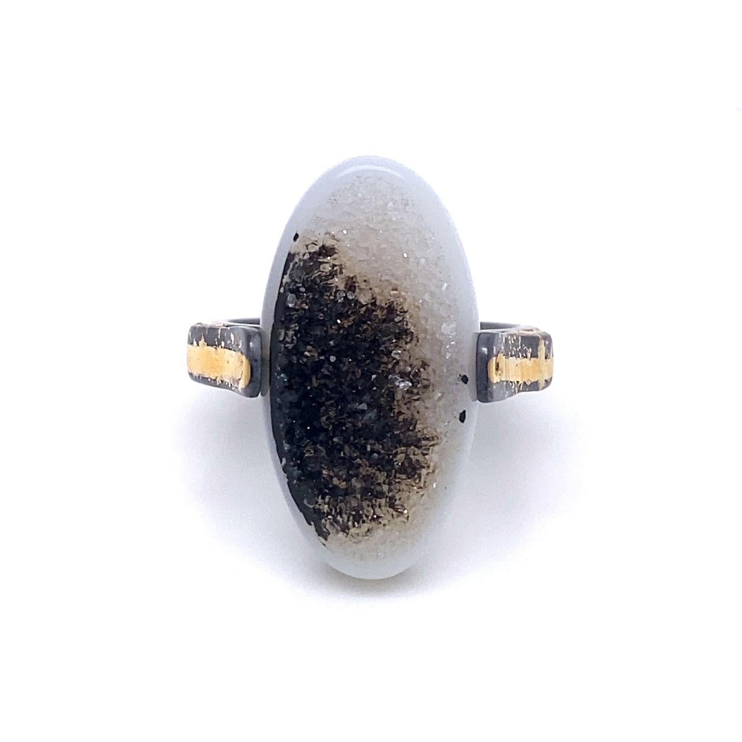 An oxidized sterling silver ring with 18k, and 22k yellow gold, with one oval black and white druzy. Ring size 8. This ring was made and designed by llyn strong.