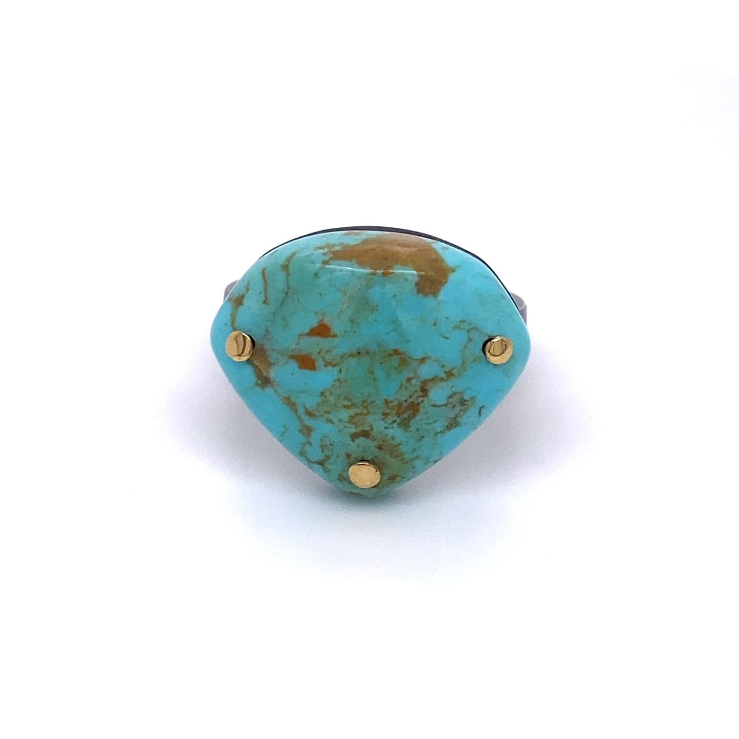 An oxidized sterling silver and 18k yellow gold with one shield shaped Kingman turquoise. Ring size 7.5. This ring was made and designed by llyn strong.