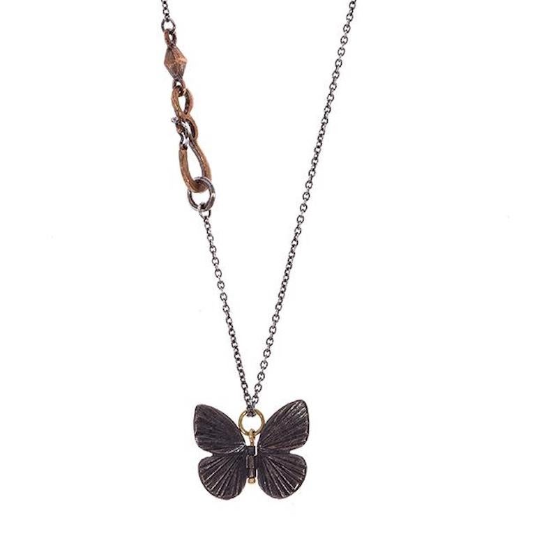 James Banks's signature butterfly necklace features a Baby Asterope butterfly with a hinge at the center to allow movement of the wings, set in Oxidized Sterling Silver with an 18k Yellow Gold hook, hung on a 17