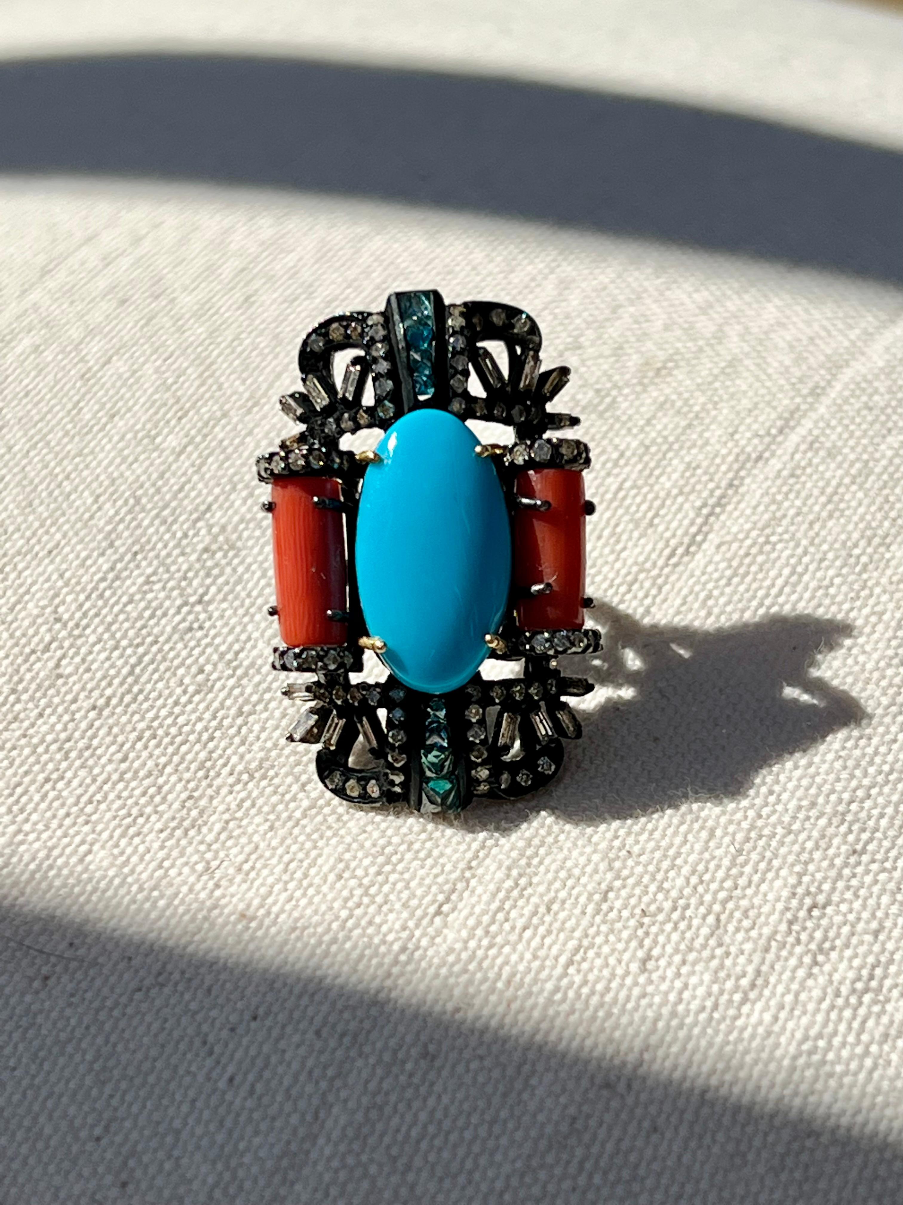 One oxidized sterling silver ring set with one 19.5x10.8mm oval cabochon turquoise stone, two (2) 11x5mm tube coral stones, one hundred seven ( 107) round brilliant cut diamonds, approximately 0.99 carat total weight with matching I color and SI2