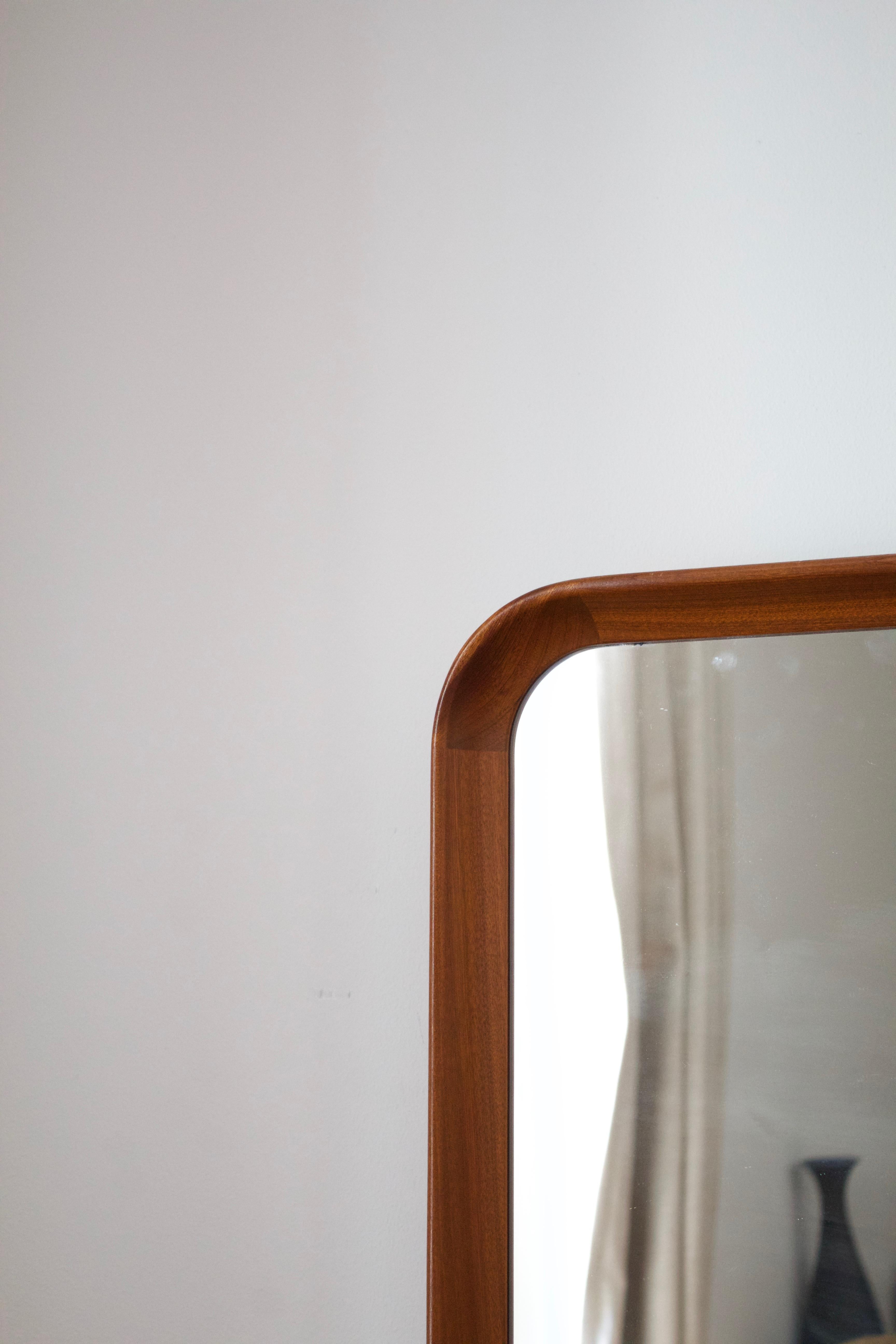 A wall mirror with its original mirror glass, solid teak frame. Produced by Oy Stockmann Ab, Keravan puusepäntehdas, Finland, 1950s. Stamped.

Rigid and of high production quality, typical of goods commissioned by Stockmann, the high-end