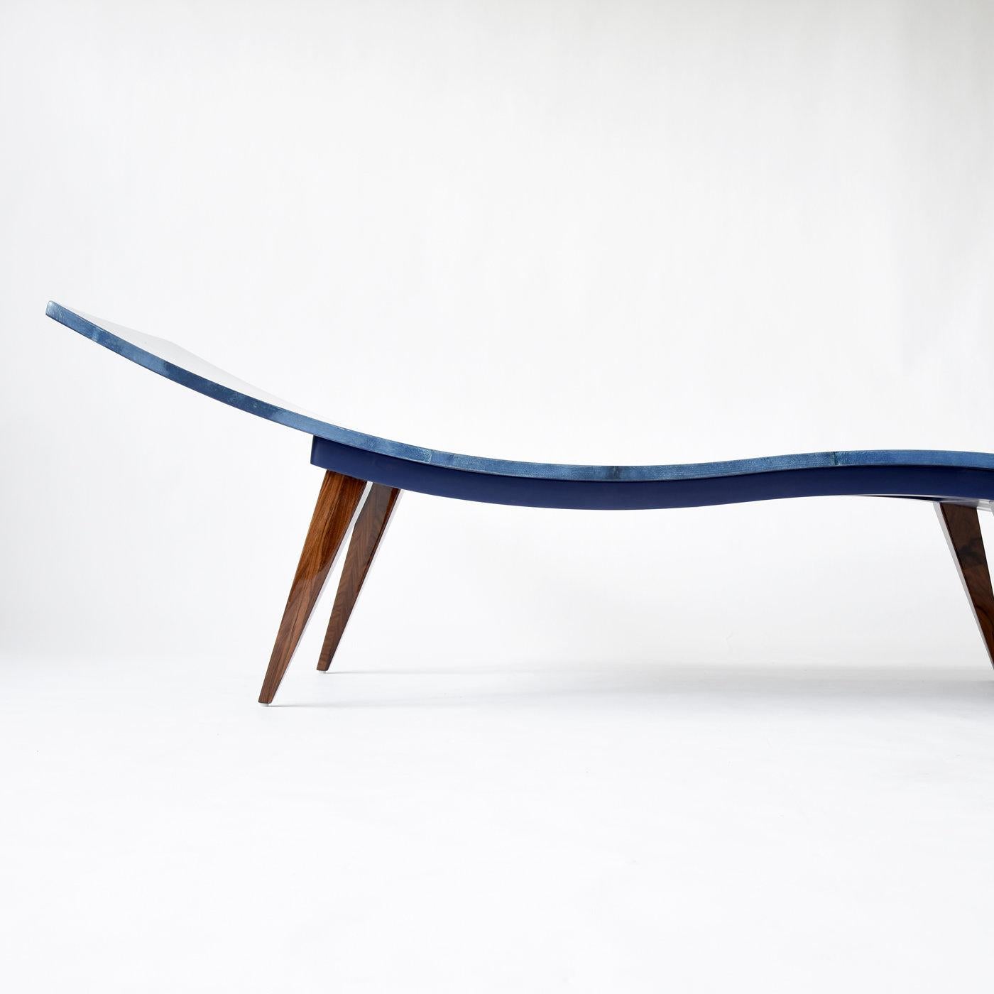 Chaise Longue in curved wood covered with matt blue parchment (goatskin) in a unique effect. The rosewood legs have a gloss finish, creating an elegant, modern and sophisticated contrast. Suitable for relaxation in the home or office, or as an