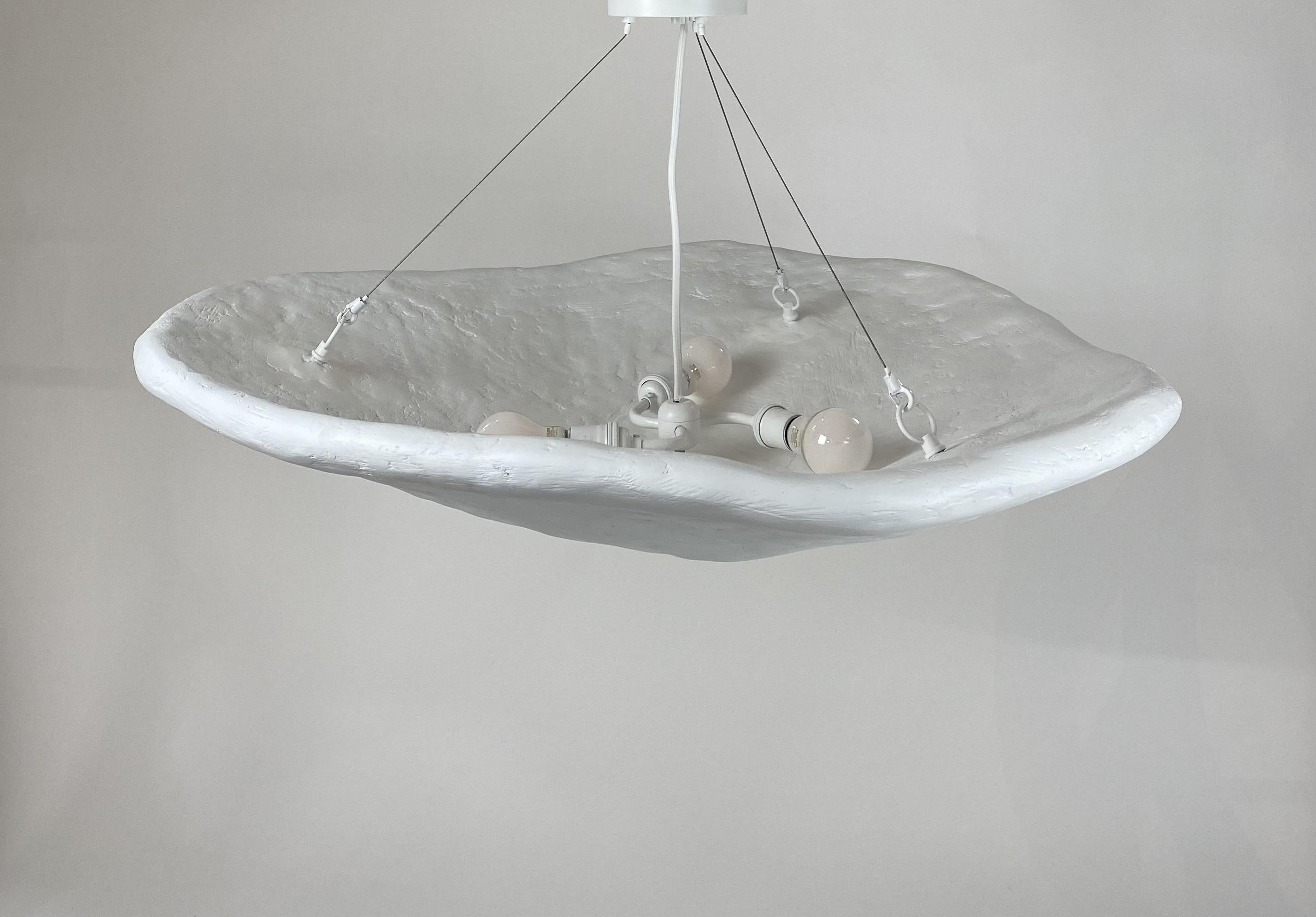 Inspired by oyster and scallop shells, the Oyster Pendant explores the juxtaposition between raw material and beauty. These pieces are composed of fiberglass, gypsum, paper pulp, and steel and come in perforated or smooth shells.

Every size can be