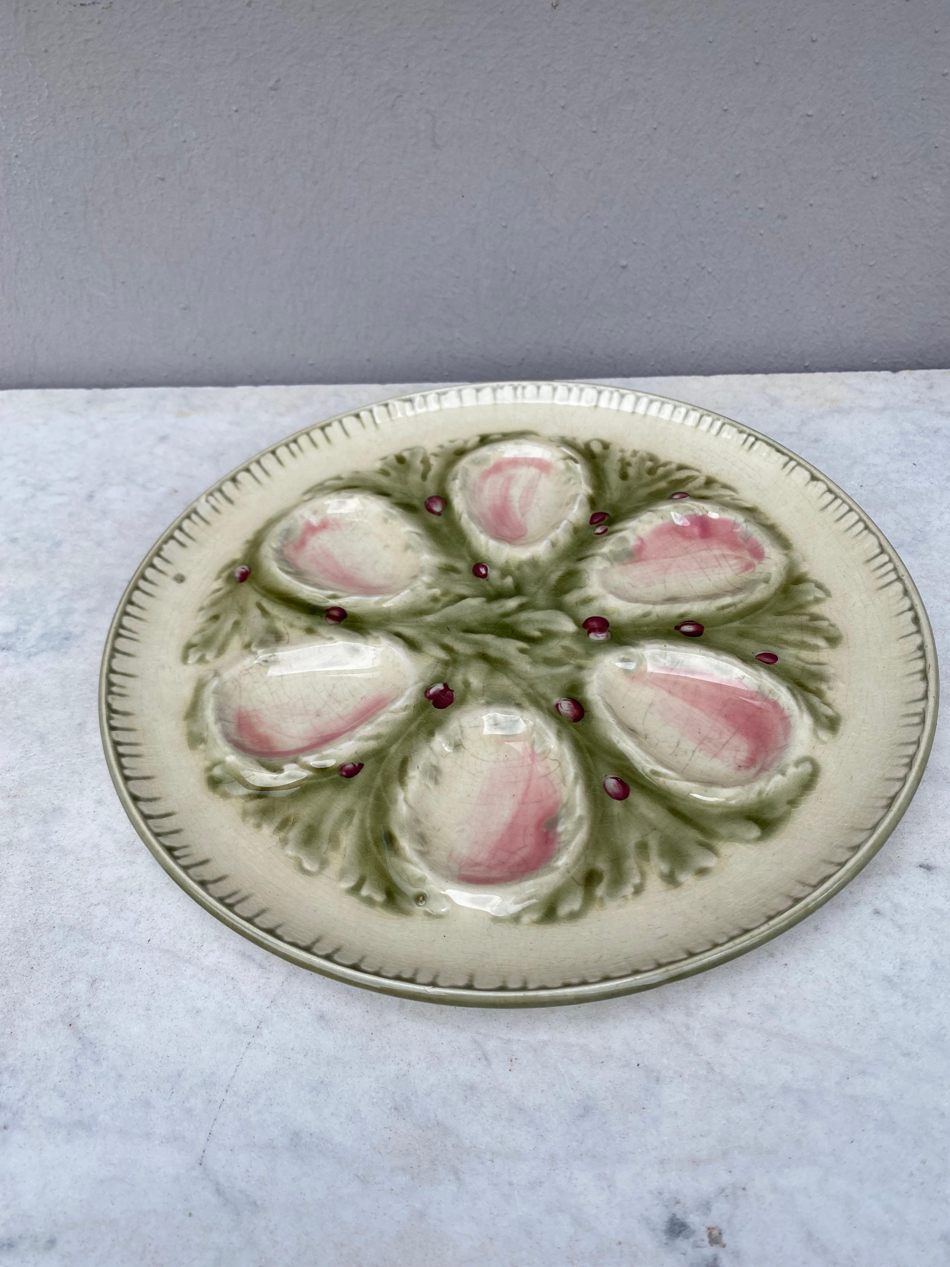 French Majolica oyster plate signed Hippolyte Boulenger Choisy-le-Roi. The six pink wells are surrounded by green seaweeds.