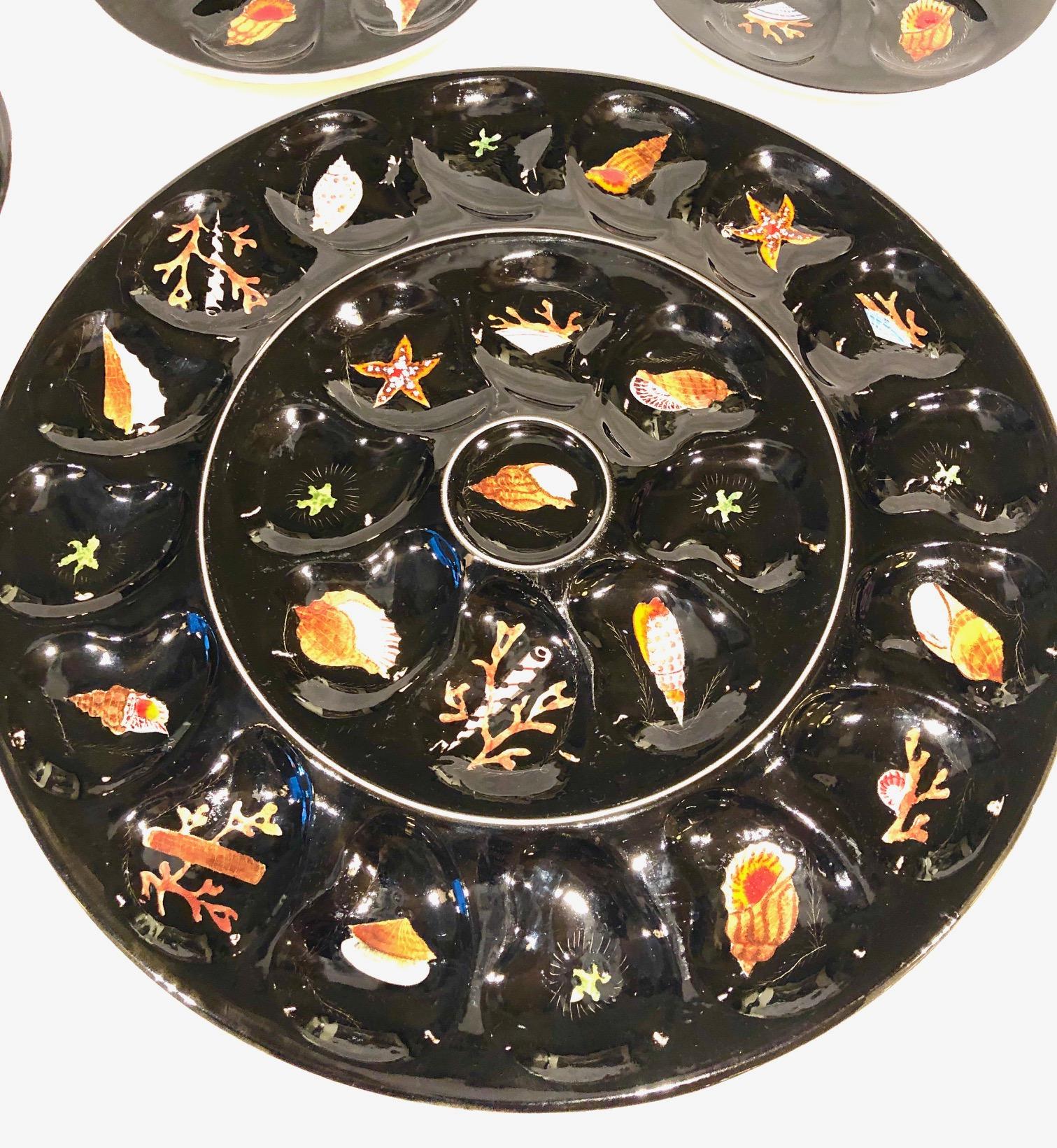 French midcentury oyster serving platter with 8 matching dishes. By French artist Guy Trevoux in the Henriot Quimper factory in the 1950s-1960s
The hand painted decor depicts shell and sea life on a black background. In very good condition.
All