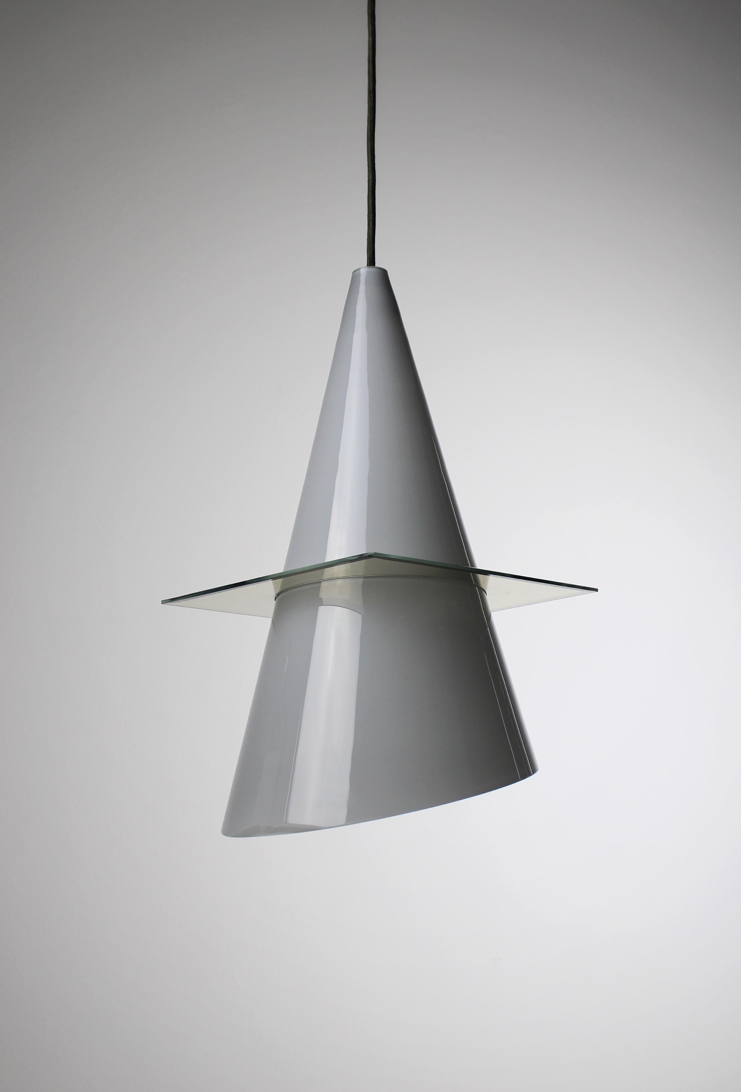 The OZ pendant lamp, designed by Daniele Puppa & Franco Raggi in 1980. Crafted by the esteemed lighting manufacturer Fontana Arte in northern Italy during the 1980s, this exquisite piece boasts a strikingly modern design. Its sleek silhouette is