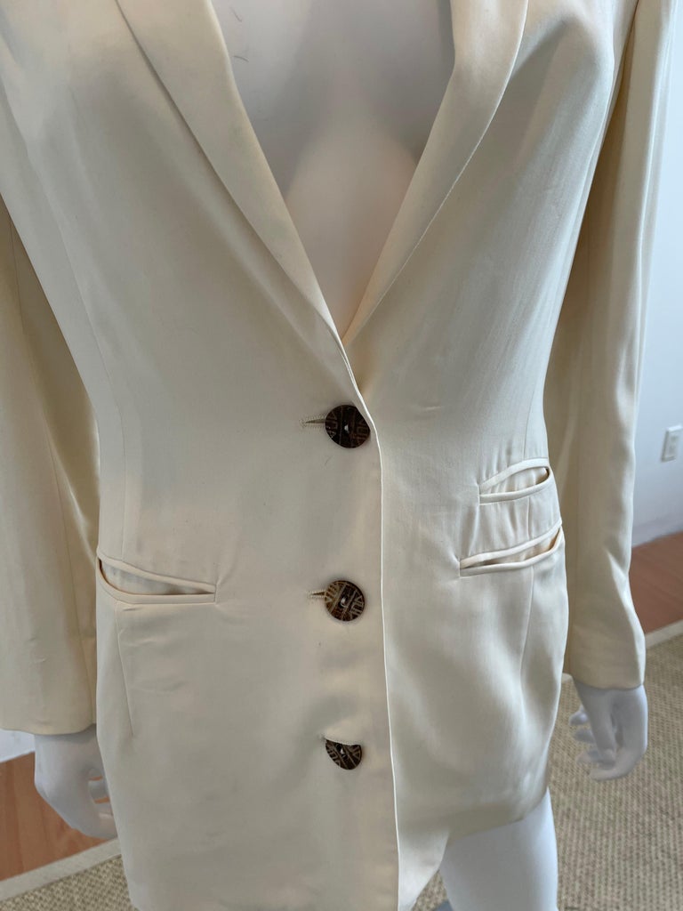 A beautiful vintage womens blazer jacket from the 90s by luxury fashion designer, Rifat Ozbek for the Ozbek line. In a luxe ivory silk, this is a great day to night transitional piece. Pockets at each side of the waist. The perfect neutral color