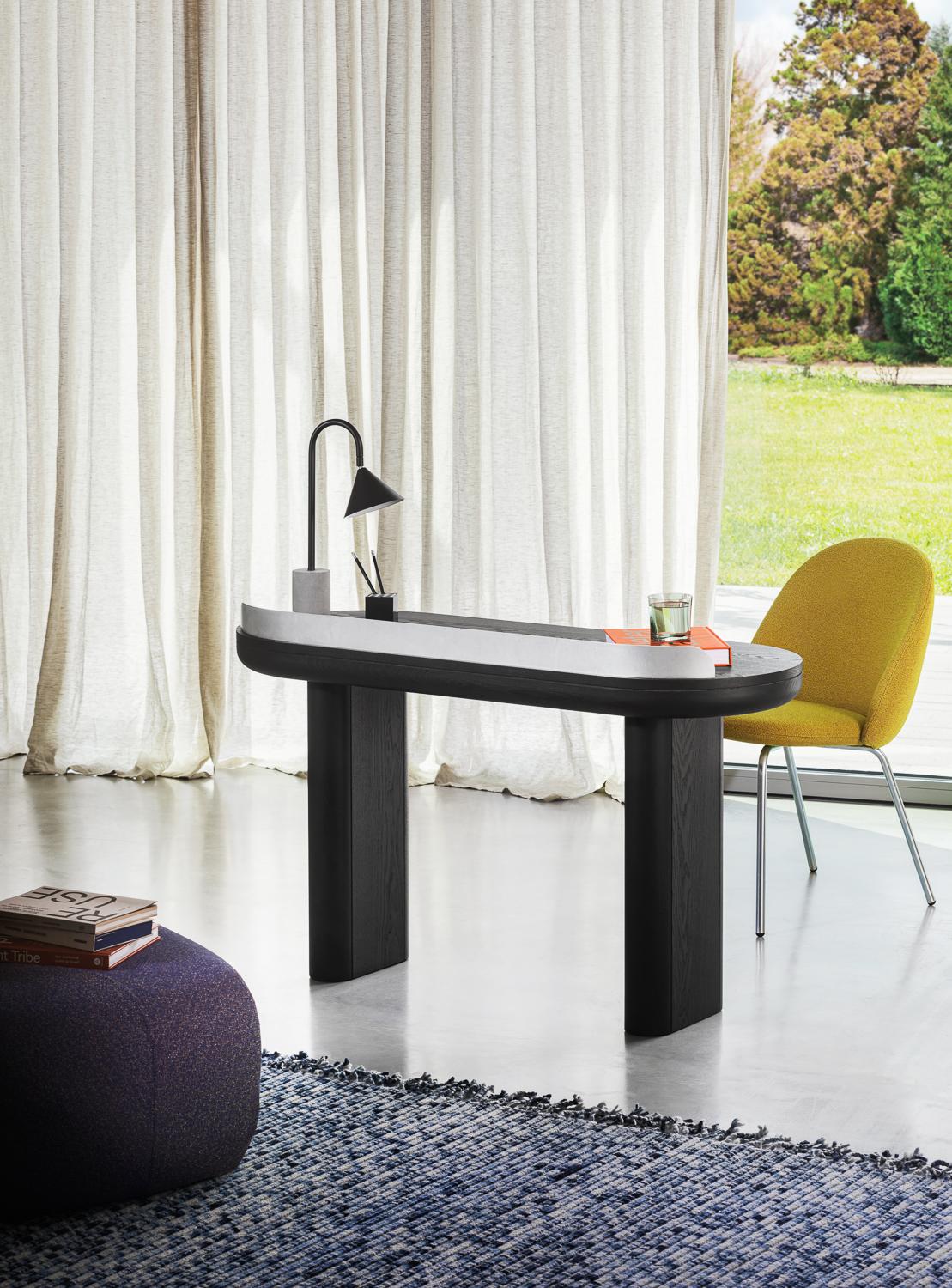 Ozz got shy, didn‘t she? Here it is in a small desk version, with an adjustable lampshade to be flexible even taking up minimum space. The counterweight appears fundamental even in the small size, keeping an intense dialogue with the lampshade and
