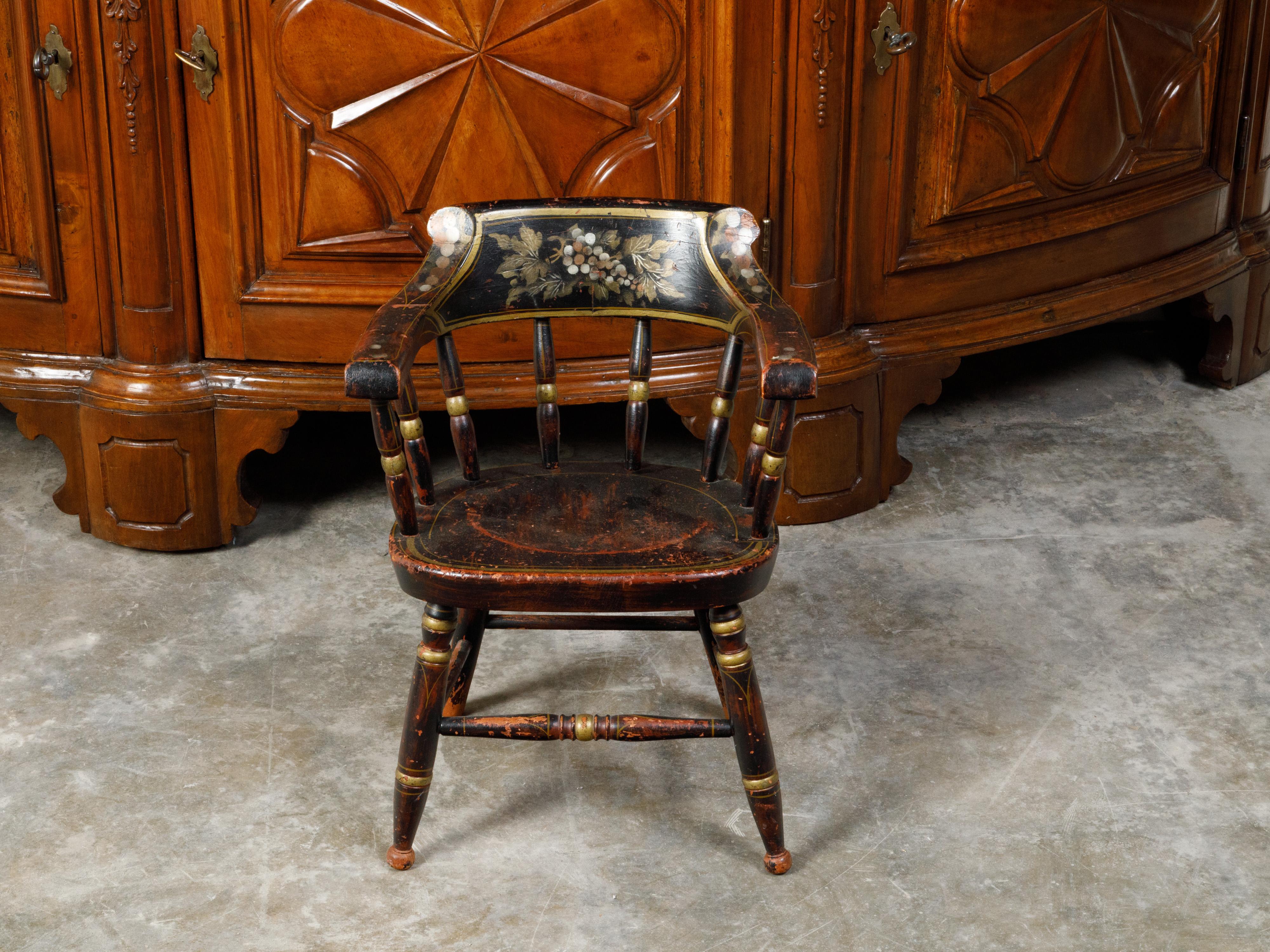 An American Lambert Hitchcock's child's chair from the 19th century, with black and gold finish and grape motifs. Created by American furniture manufacturer Lambert Hitchcock during the 19th century, this child's chair attracts our attention with