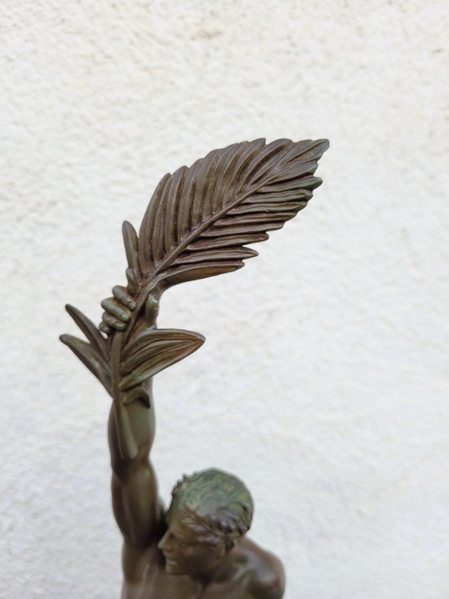 Gloria: scultura in spelta con patina verde che rappresenta un uomo seduto su un'alta base di marmo nero e che brandisce la palma della vittoria o della gloria sopra la sua testa

Scultura firmata sulla base Le Faguays (Pierre, 1892-1962), prodotta