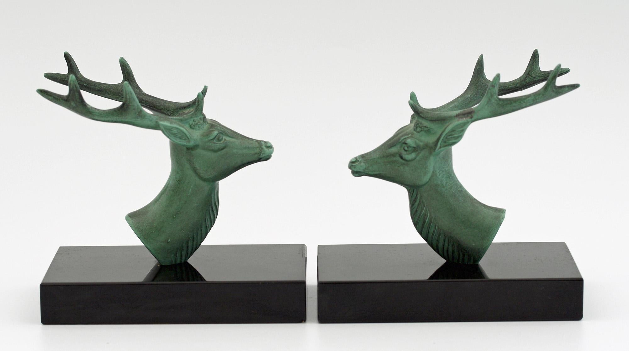 A stunning pair French Art Deco bookends mounted with metal stag heads with a wonderful green patination on black polished stone bases signed P Mimaux. The rectangular bookends have paper base protectors attached and are extremely stylish and of
