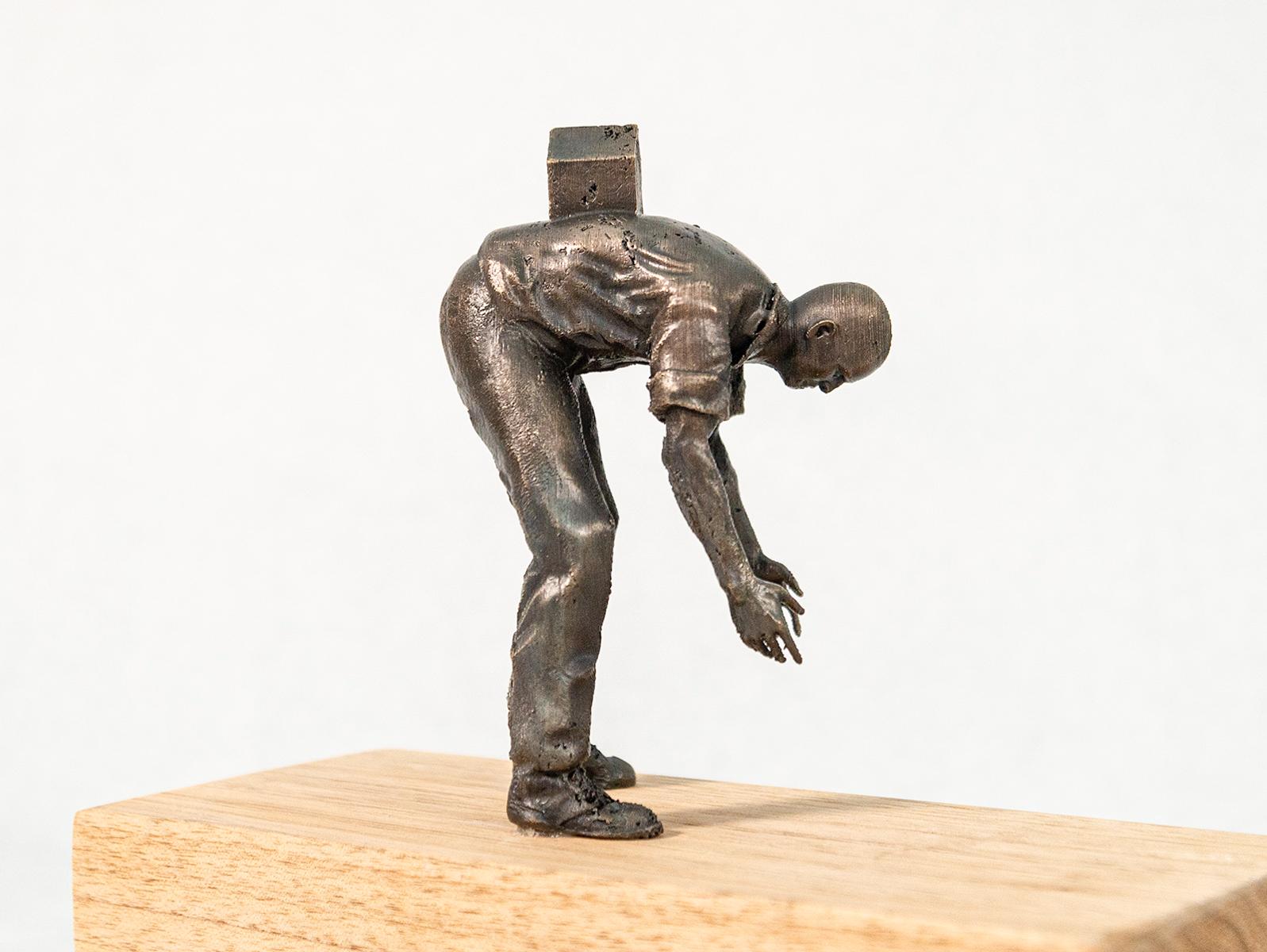 Toronto artist Roch Smith often uses toy figures in clever and fun ways to convey cultural statements that go beyond child’s play. This tabletop figure is bending over, arms extended as if he’s trying to grasp something, a small house sits on his