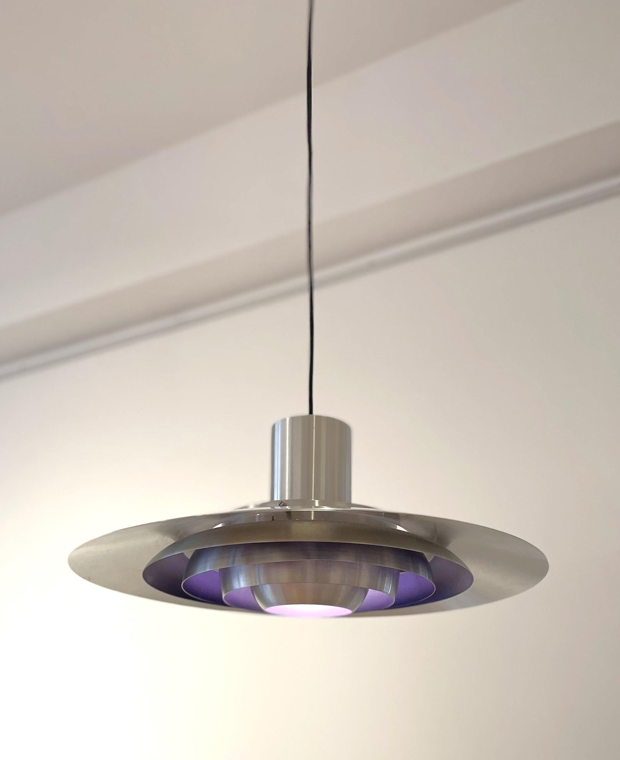 Die perfekt erhaltene Hängeleuchte P376 von Fabricius & Kastholm für Nordisk Solar ist ein Klassiker der dänischen Moderne. Das raffinierte und durchdachte Design dieser Hängeleuchte mit ihren fünf konzentrischen Schirmen spendet warmes Licht und