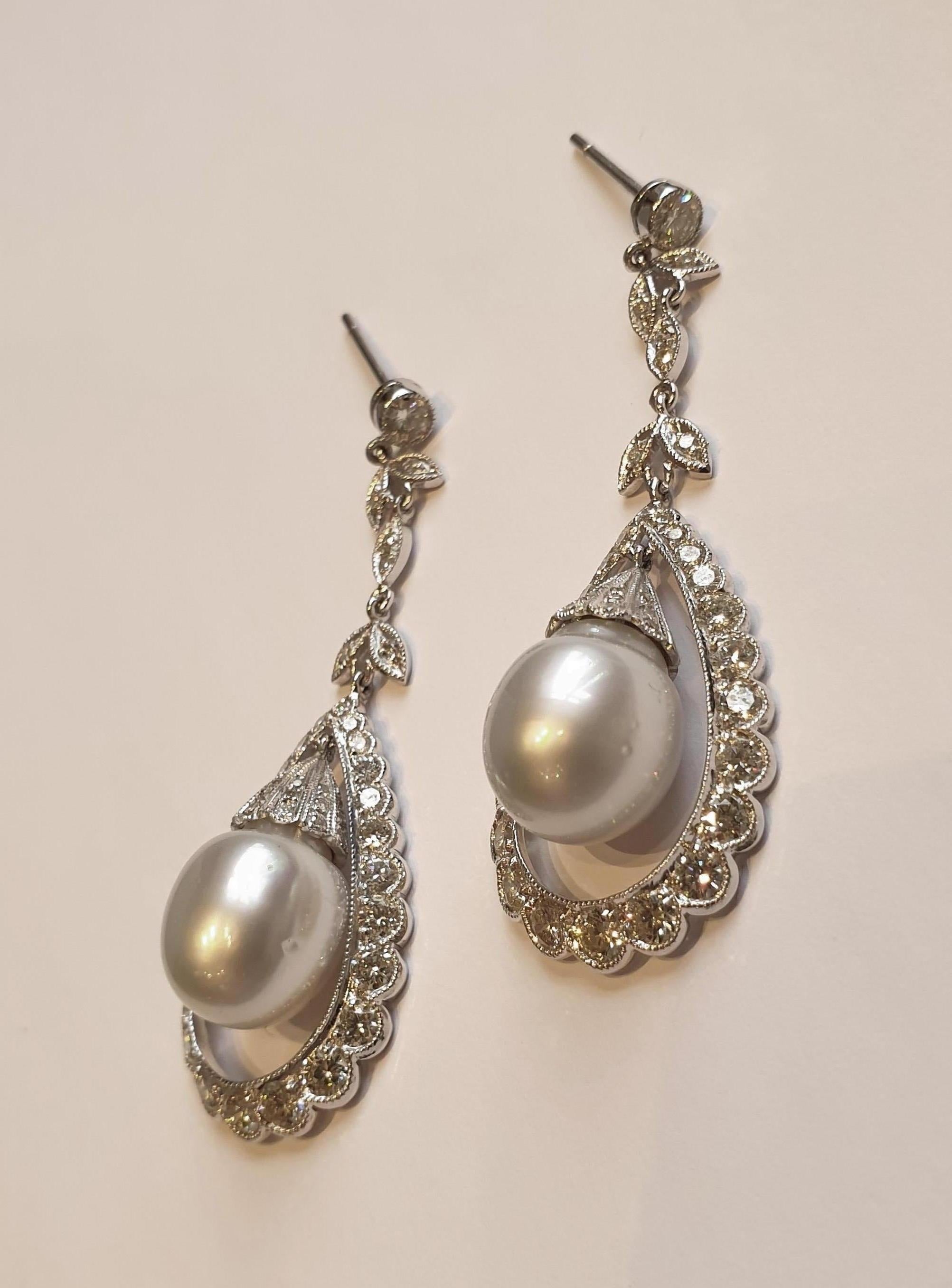 Art Deco style, Sweden about 1930. Set mounted in 18 carat white gold. Each earring with a white South Sea pearl measuring 4.49 in ( 11,4 mm ) in diameter. Bordered by 92 brilliant-cut diamonds with a total weight of ca. 4,02 ct. Millegrain setting.