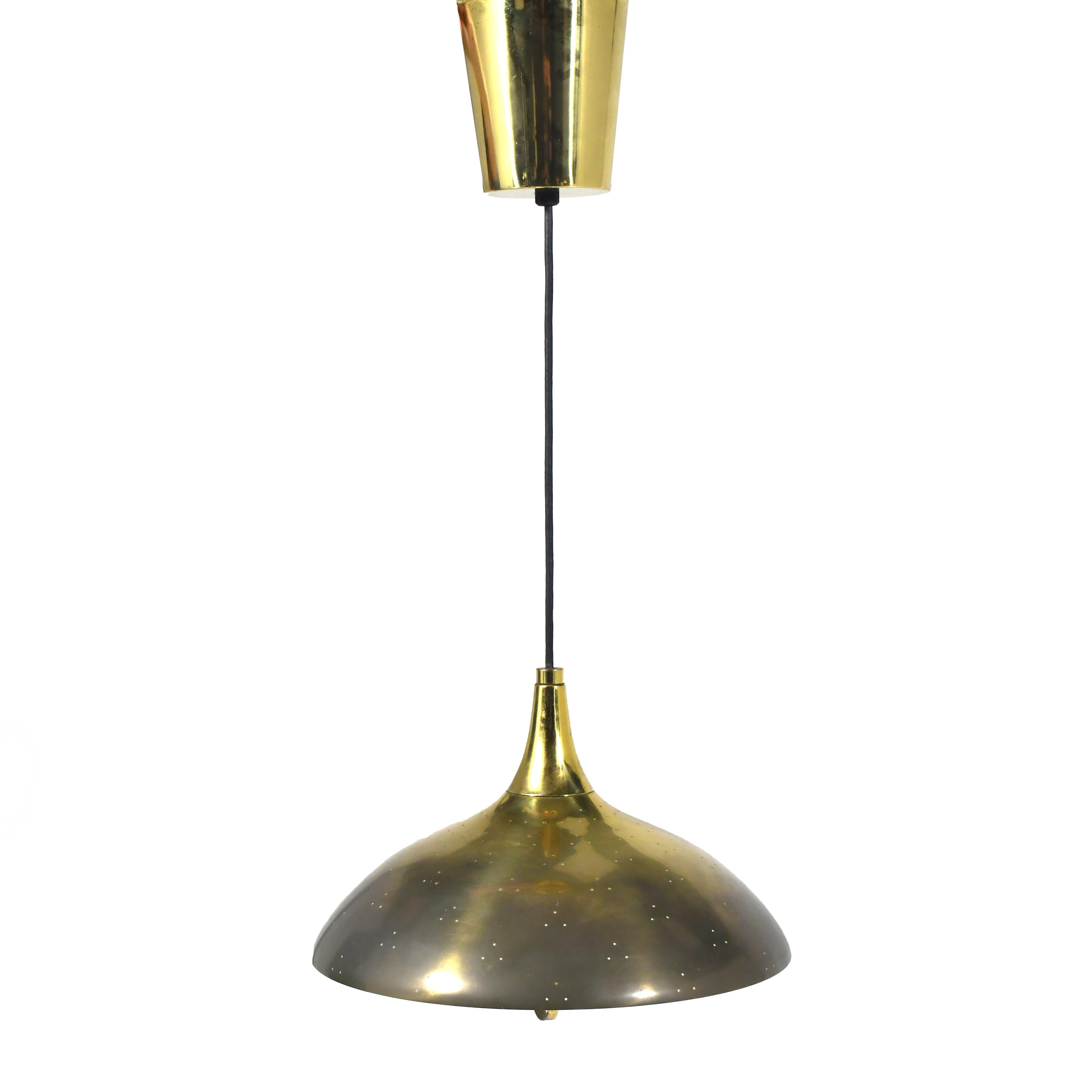 Un design sublime di Tynel, questa lampada a sospensione in ottone ha un bellissimo paralume con una sottile perforazione.  un diffusore in vetro e una maniglia fine che permette di regolarne l'altezza tramite un meccanismo nascosto nel baldacchino