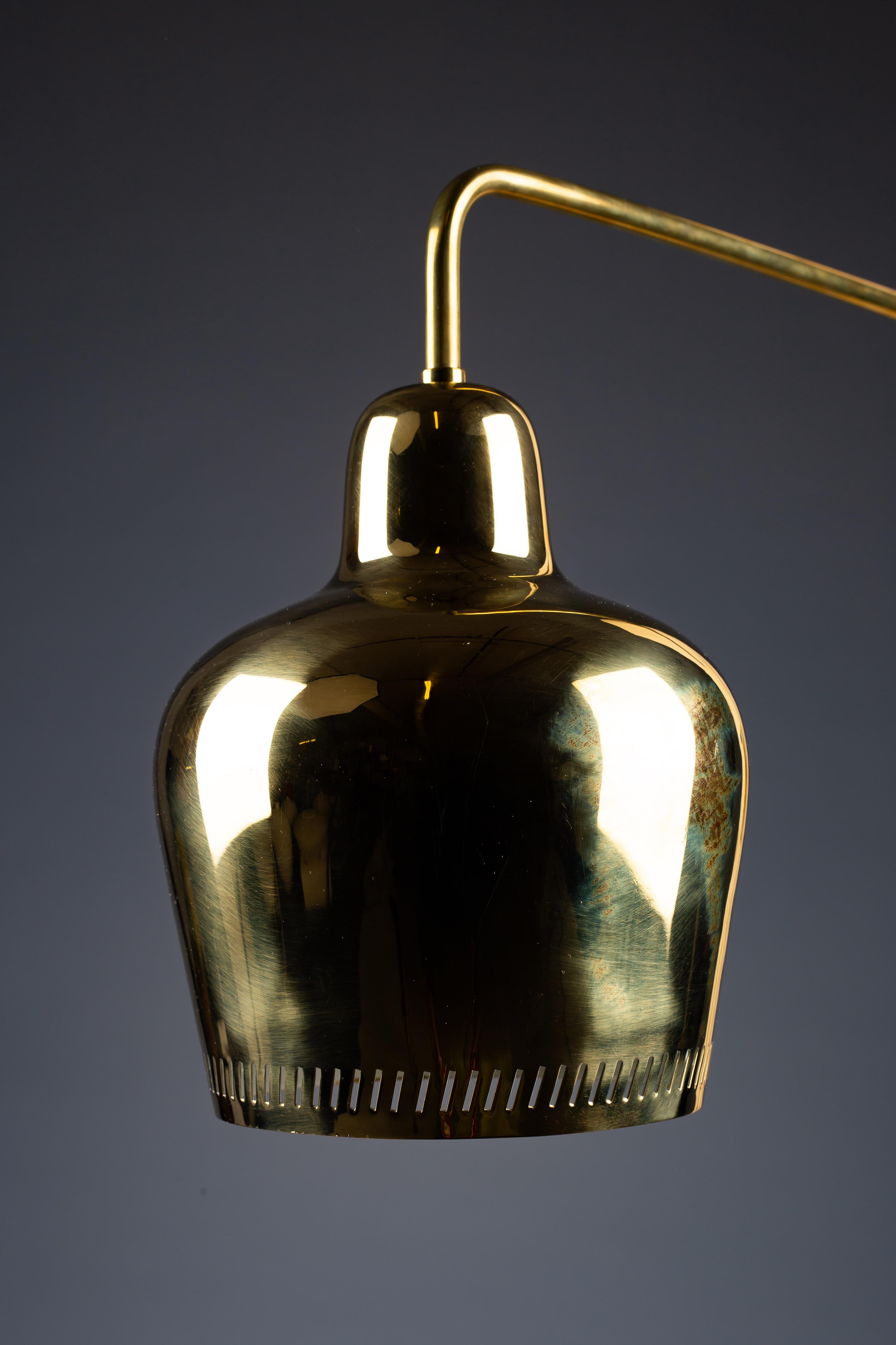 Scopri la rara campana d'oro di Paavo Tynell, un vero gioiello degli anni '40 che abbellisce questa elegante lampada da parete 1699 per Taito Oy. Caratterizzato da un elegante albero a parete laterale e realizzato in ottone lucido, questo pezzo