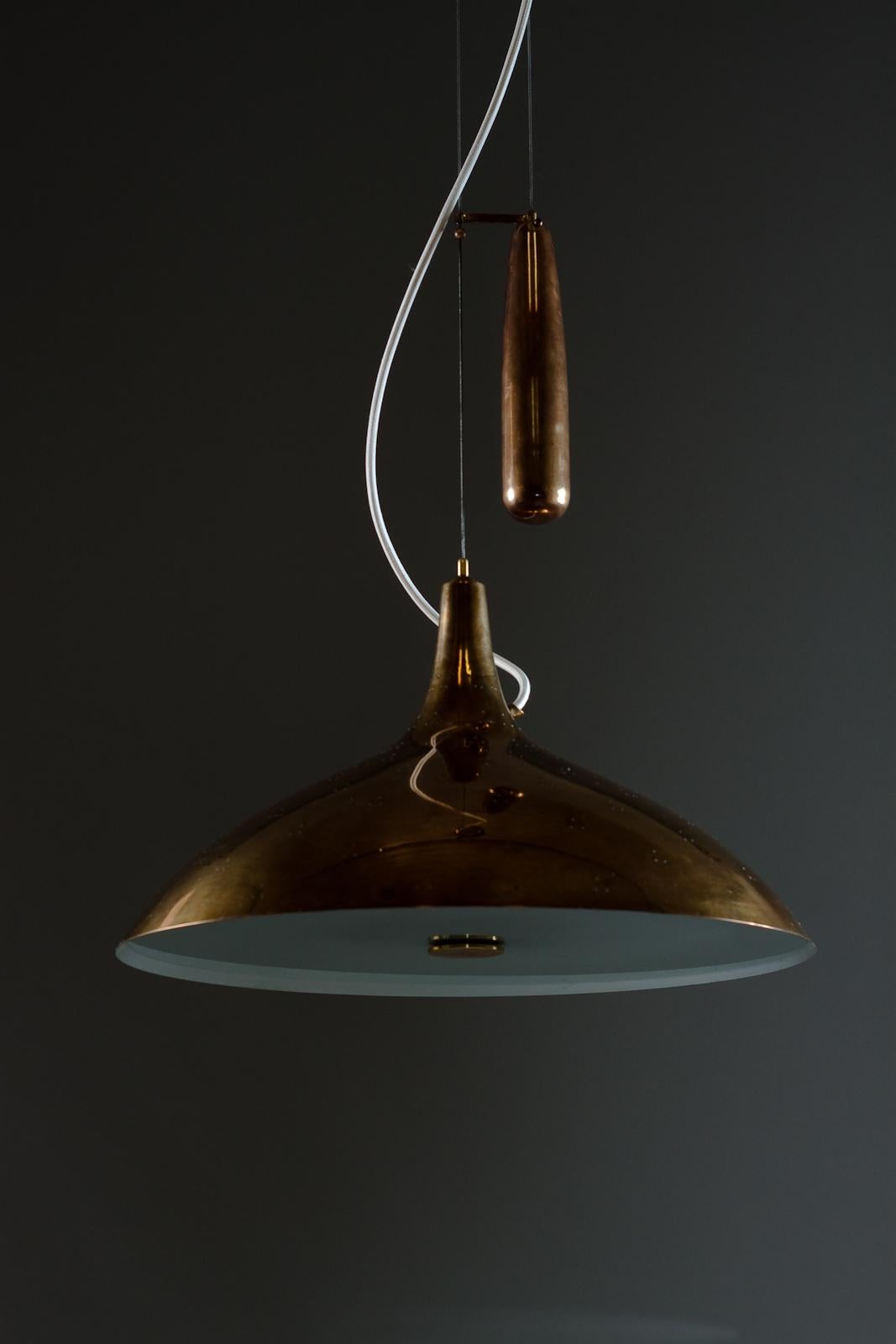 Beautiful designed pendant lamp by Paavi Tynell for Taito Oy. The patina and quality of brass is very high, not like the materials in the new production lamps.
The height can be adjusted due to the wire that is adjustable in length. This counter