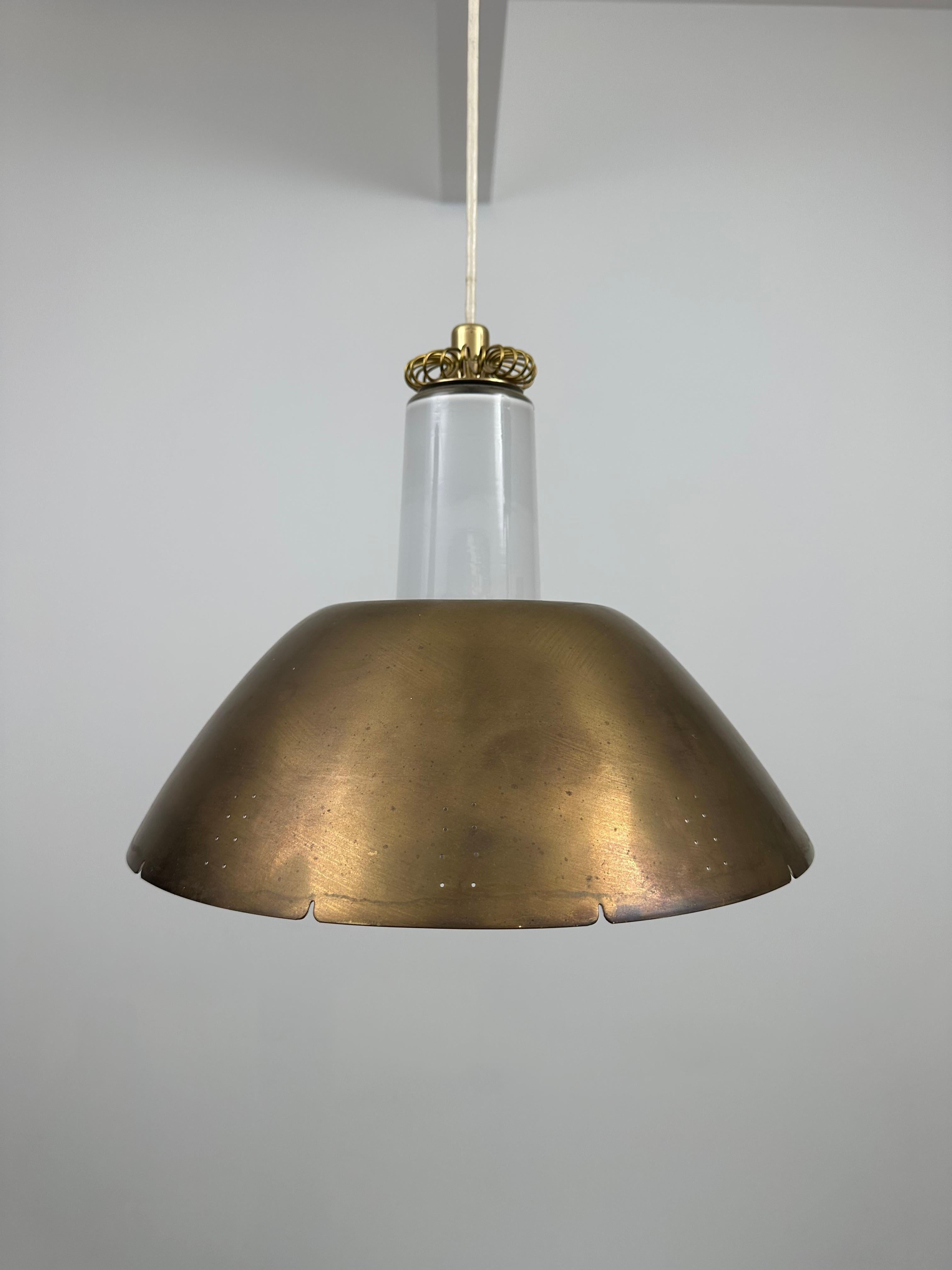 Pendente in ottone e vetro opalino del 1950, modello K2-20 di Paavo Tynell per Idman Oy Finlandia
Paralume a cupola in ottone non lucidato su diffusore in vetro smerigliato soffiato a bocca.
Un bellissimo e raffinato dettaglio floreale a rosetta in