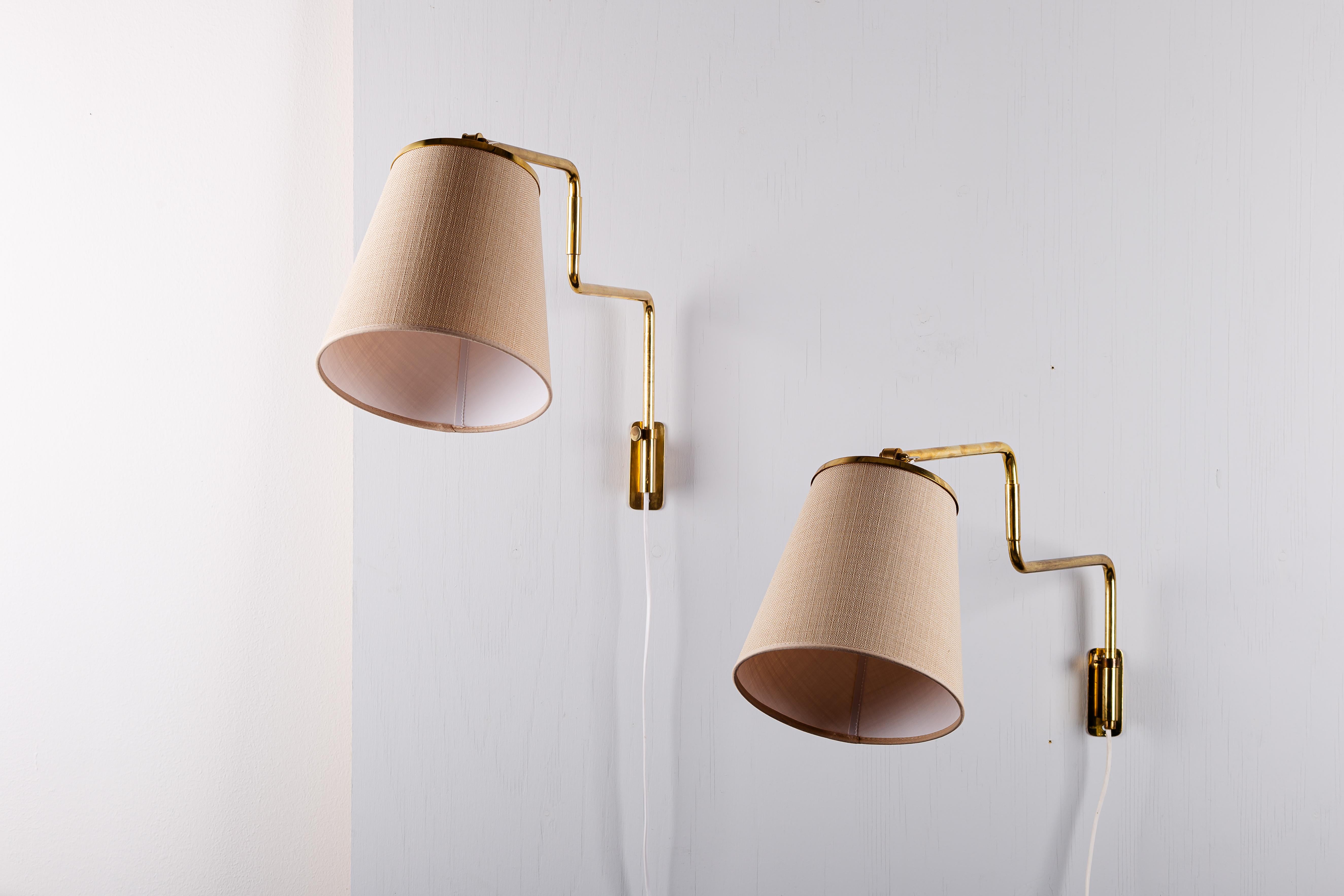 Eleva tu hogar con la elegancia atemporal del par de apliques de latón de Paavo Tynell, modelo 9414 para Taito Oy. Fabricados en exquisito latón, estos apliques reflejan el sello distintivo del diseño vintage escandinavo, combinando funcionalidad y