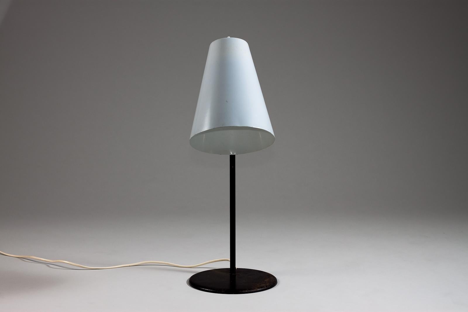 Introducing the timeless beauty of Paavo Tynell's 1960's table lamp, designed for Idman Oy in Finland. The lamp boasts a simple yet elegant design, bringing a touch of vintage charm to any living or workspace. It emits a gentle, warm illumination,