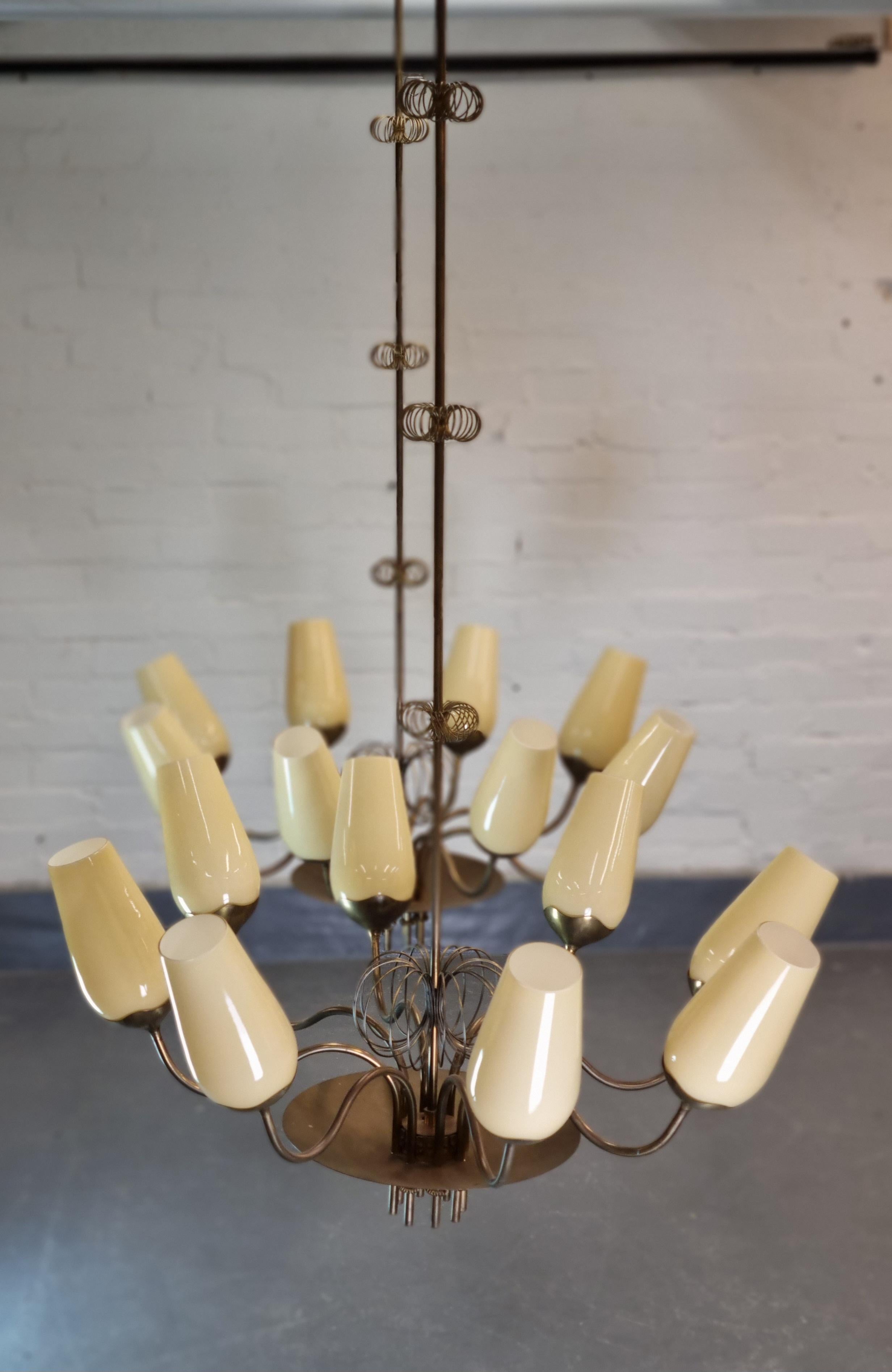 An exquisite pair of commissioned chandeliers by Paavo Tynell early 1950s with a geniously designed structure that has eight arms protruding from a central cup decorated with a flower like spring with another three springs on the central shaft of