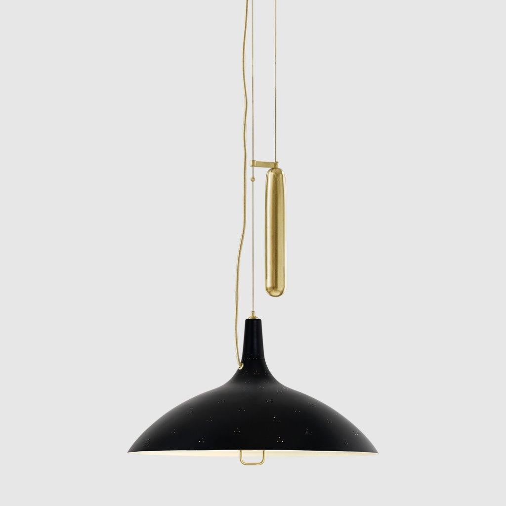 Paavo Tynell 'A1965' counterweight pendant lamp in black. Originally designed by Paavo Tynell in 1947, this authorized GUBI re-edition is executed in a perforated brass metal shade with white interior and glass diffuser. Like many of his iconic