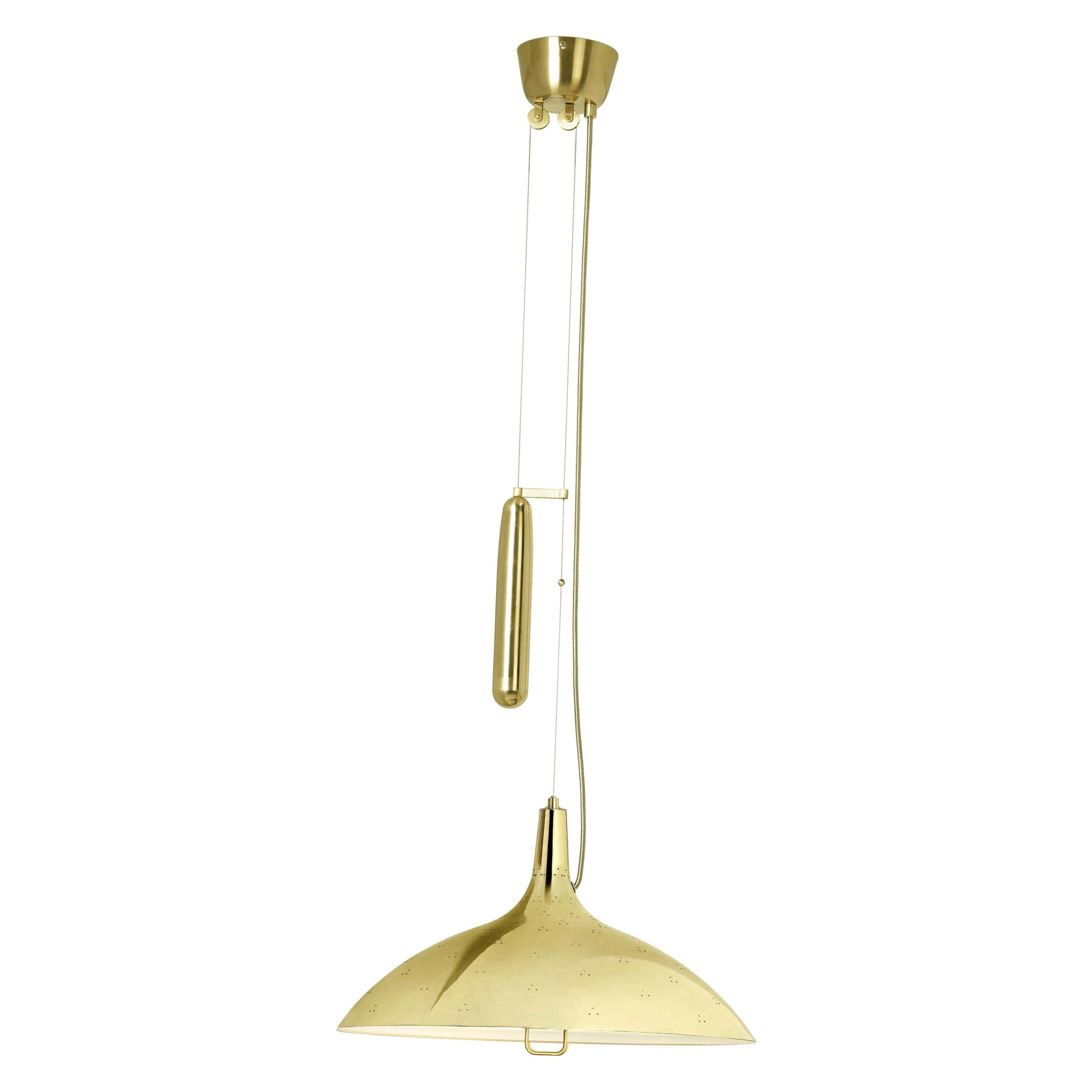 Paavo Tynell 'A1965' lampe suspendue à contrepoids en laiton. Conçue à l'origine par Paavo Tynell en 1947, cette réédition autorisée de GUBI est exécutée dans un abat-jour en laiton perforé avec intérieur blanc et diffuseur en verre. Comme nombre de